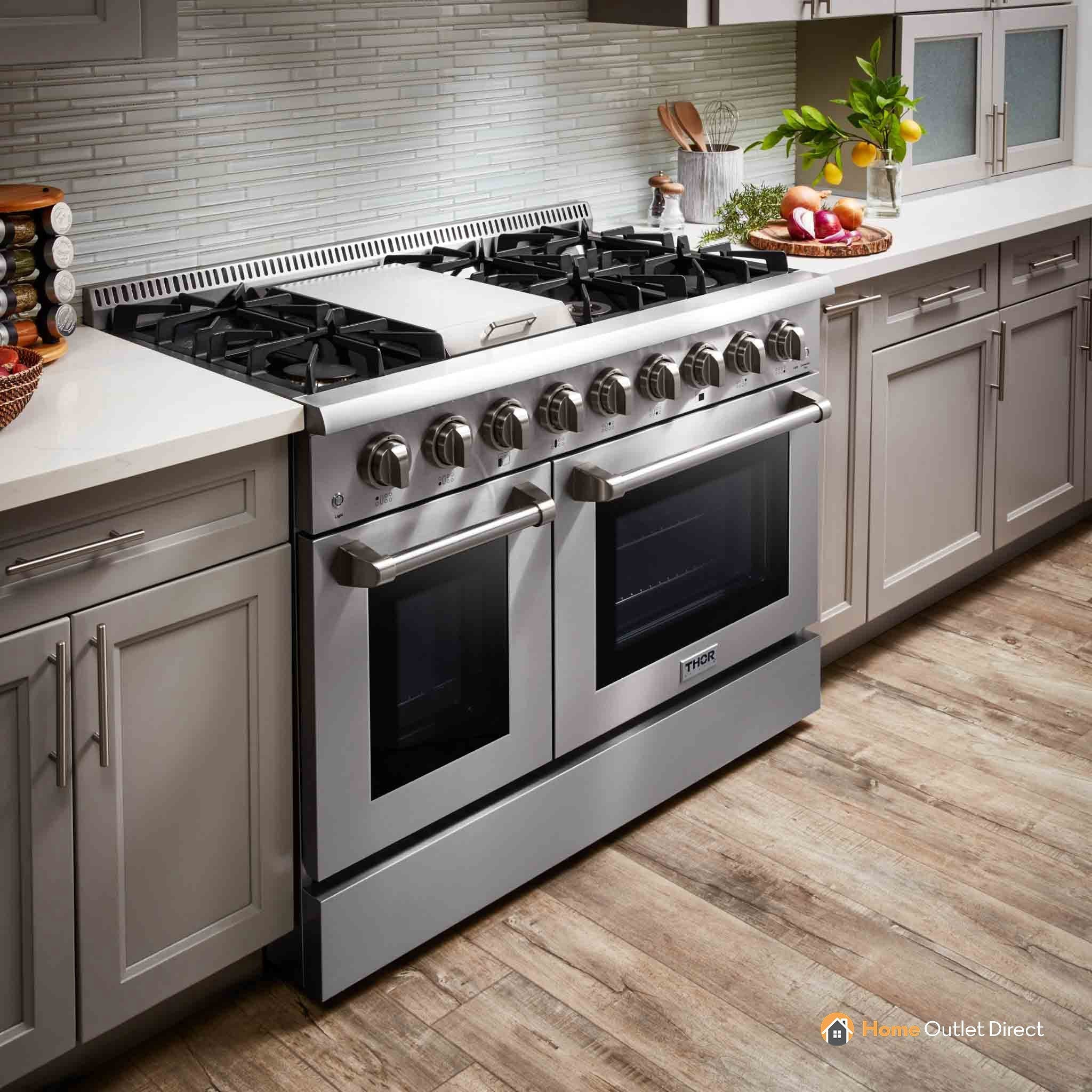 Stainless steel dual fuel range with side doors and burners, angled view in kitchen.