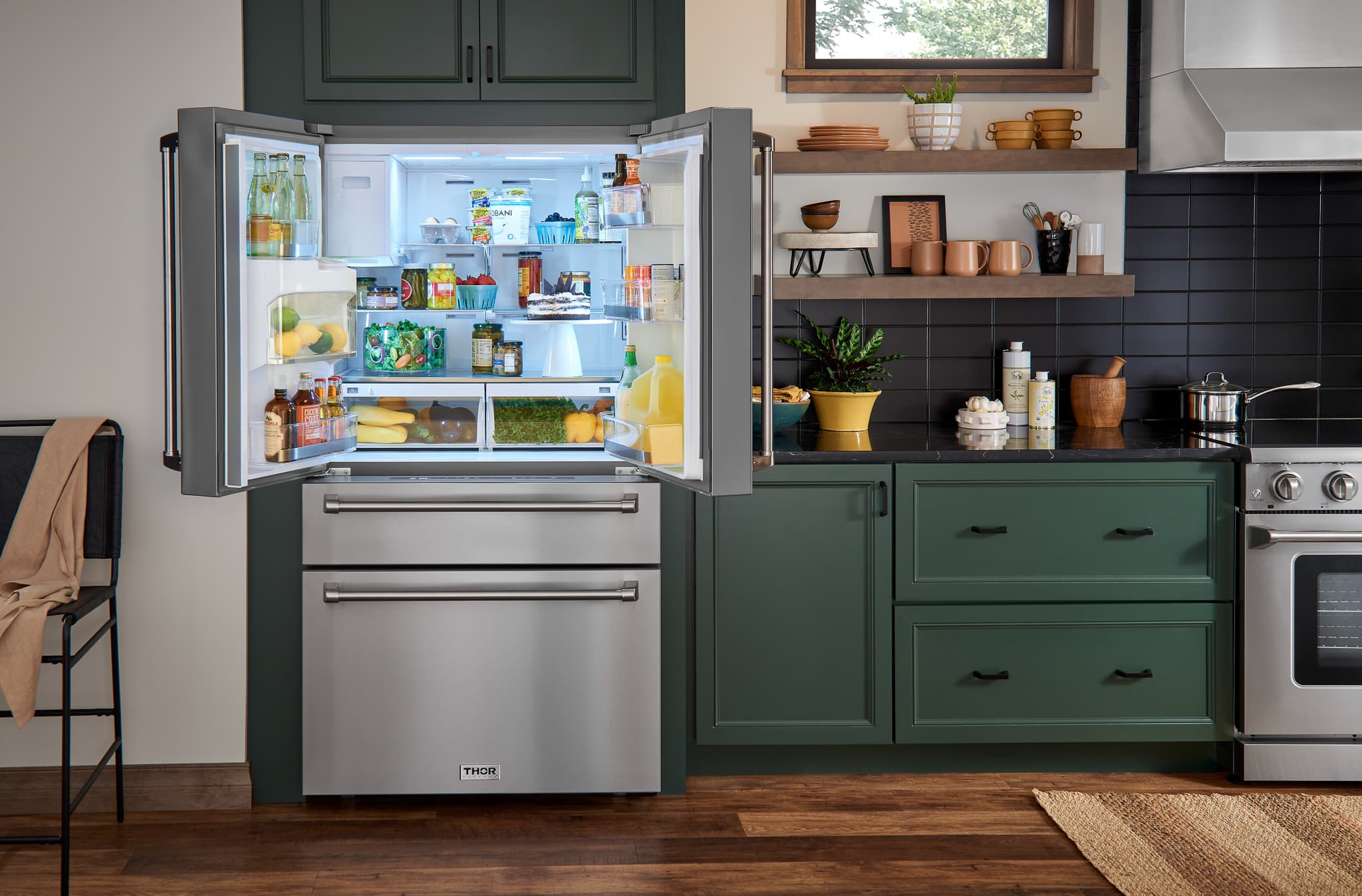 Stainless refrigerator with door open and bright interior shelves, in kitchen.