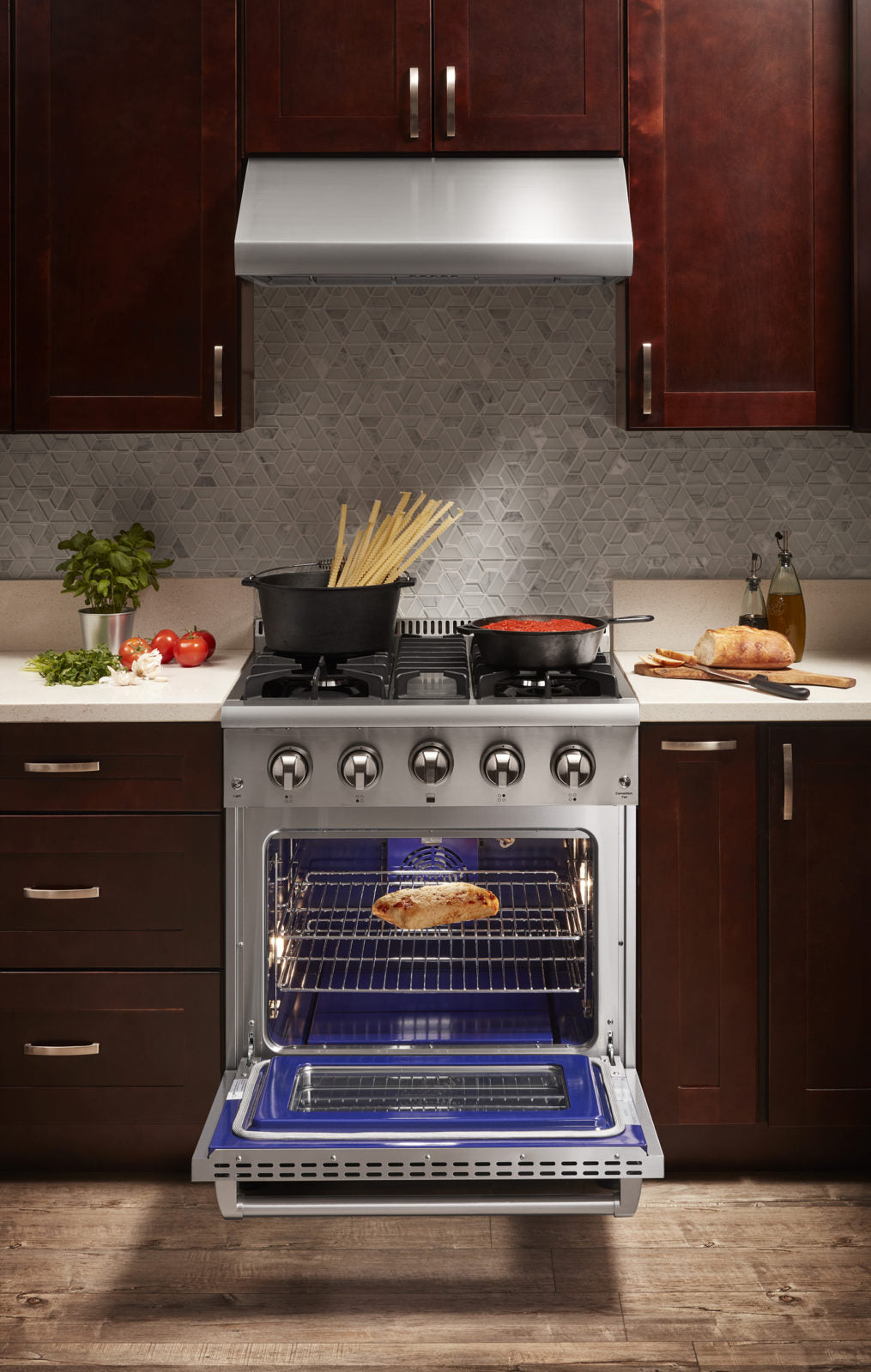 Stainless steel dual fuel range with oven door open and cooktop burners above