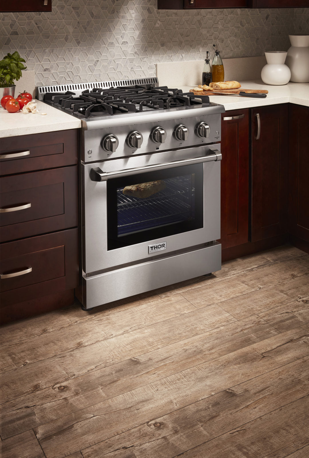Stainless steel dual fuel range with four control knobs and oven door closed