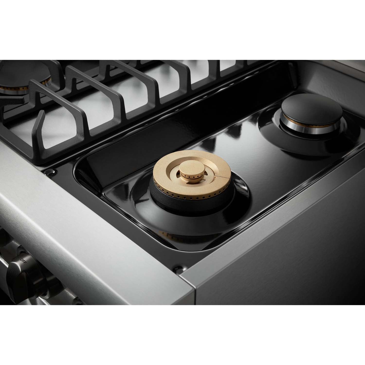Stainless steel gas range cooktop with black burner and circular brass-style cap