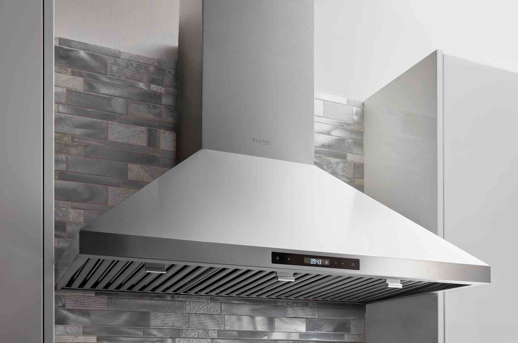 Stainless steel wall mount range hood with angled chimney and vent canopy