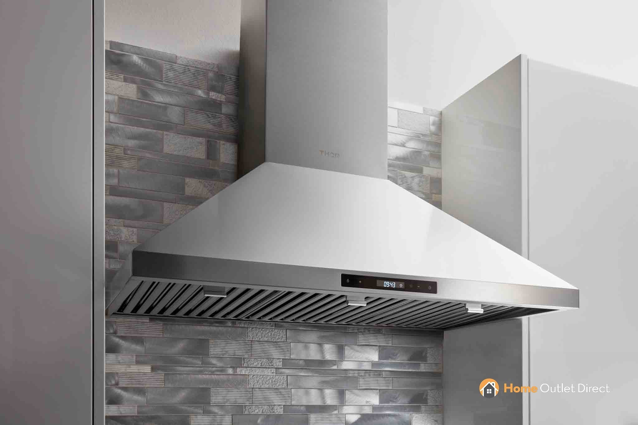 Stainless steel chimney range hood above backsplash, with slim control strip