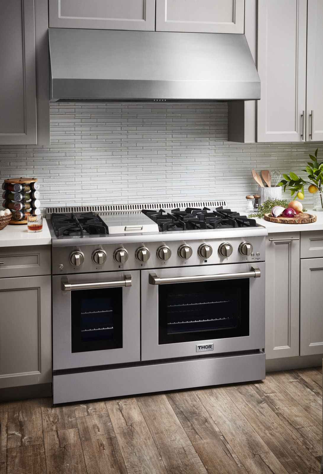 Stainless dual fuel range front with closed oven doors, knobs, and gas burner grates