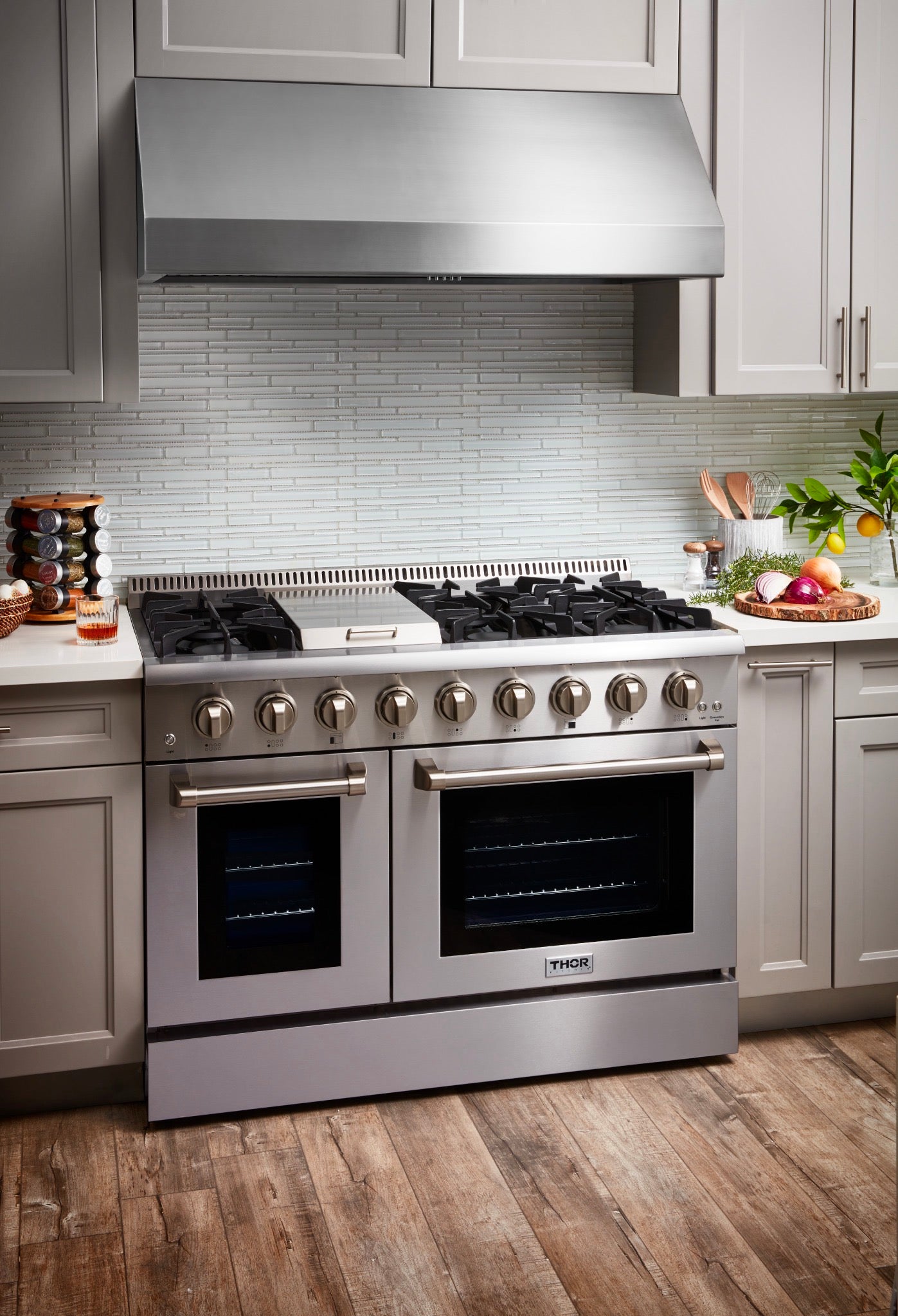 Stainless steel double-oven gas range with open-door oven windows and burner grates