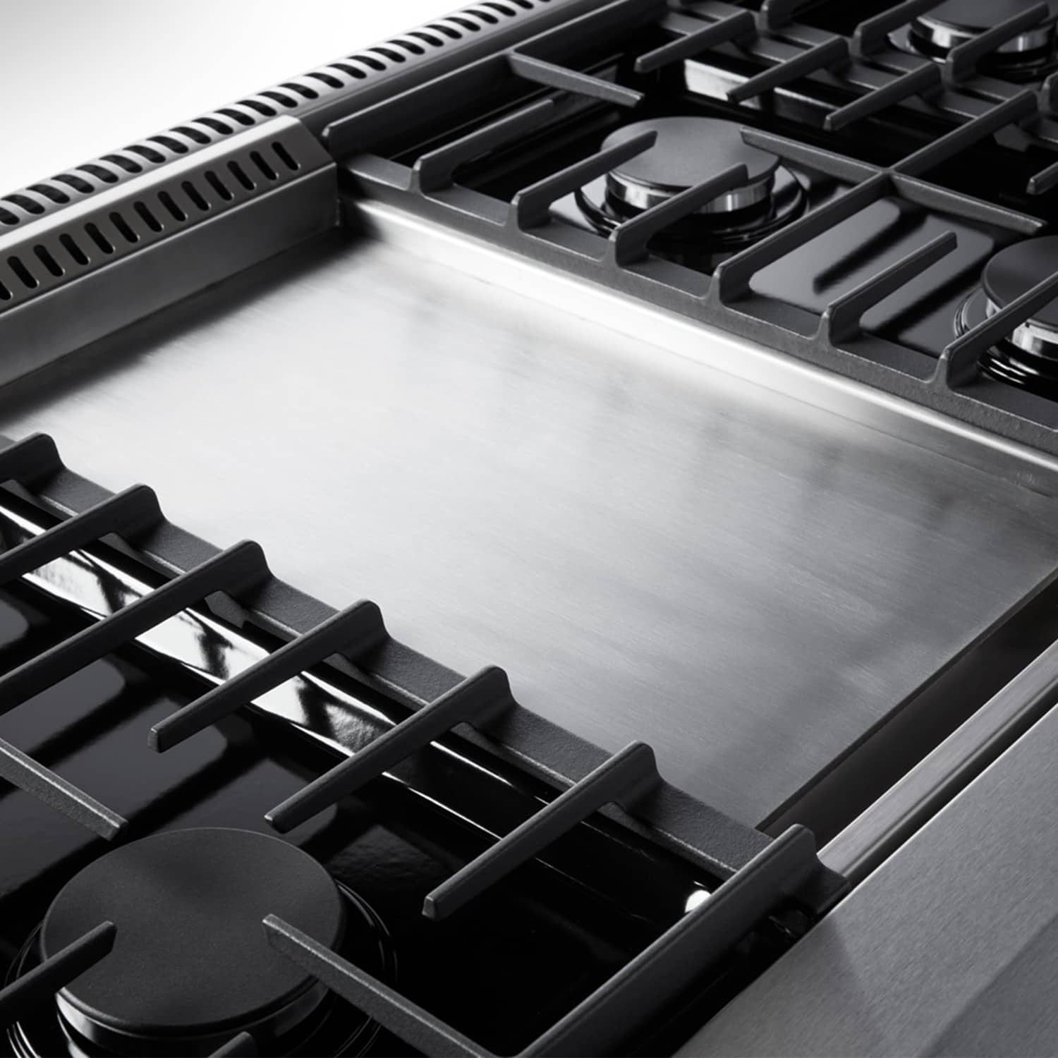 Stainless steel cooktop with black burner grates on a double oven gas range