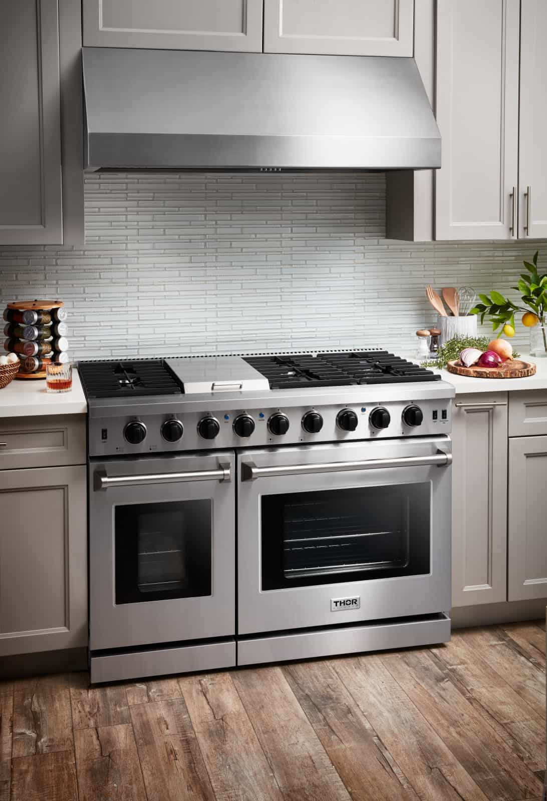 Thor 48-inch gas range with stainless body, black grates, and dual oven doors