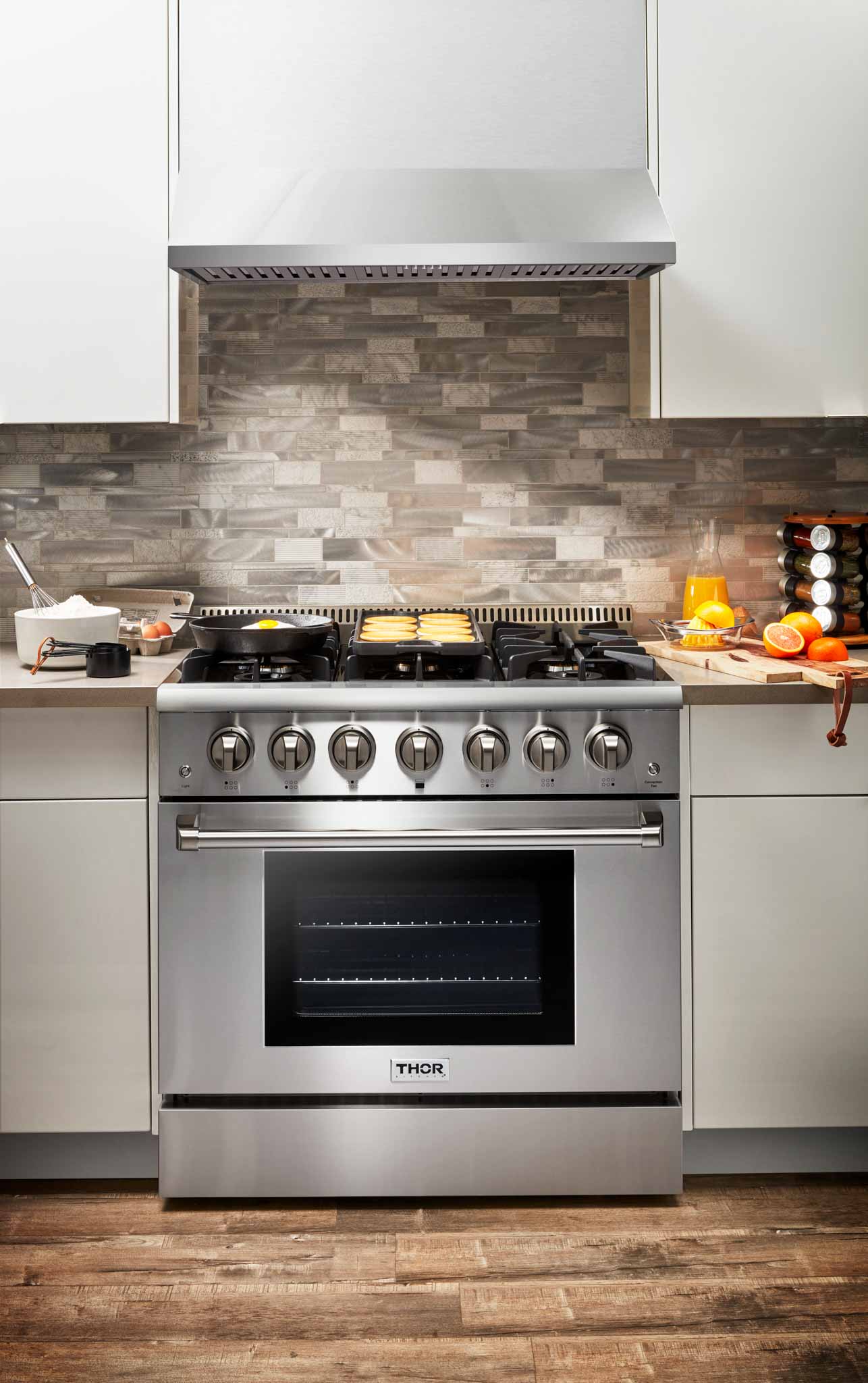 Stainless steel gas range with six burners, control knobs, and oven door below.