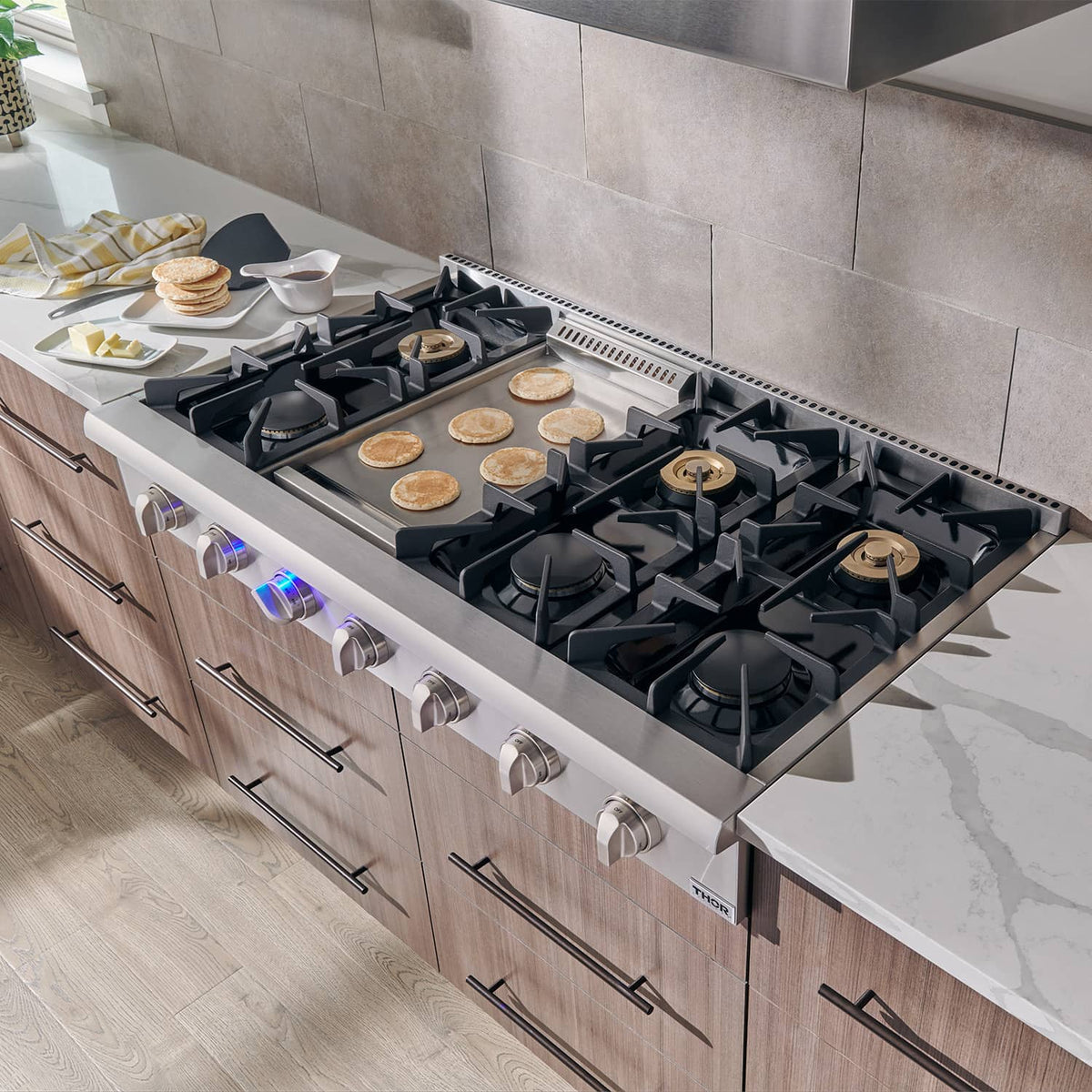 Stainless gas range cooktop with black burner grates and cooktop surface