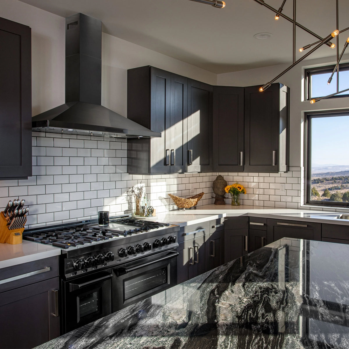 Convertible wall mount range hood in black stainless steel above a cooktop