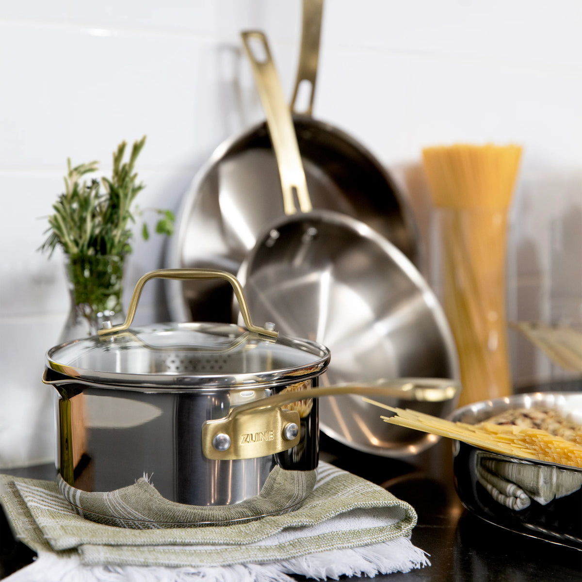 Small stainless steel pot with lid and gold handles