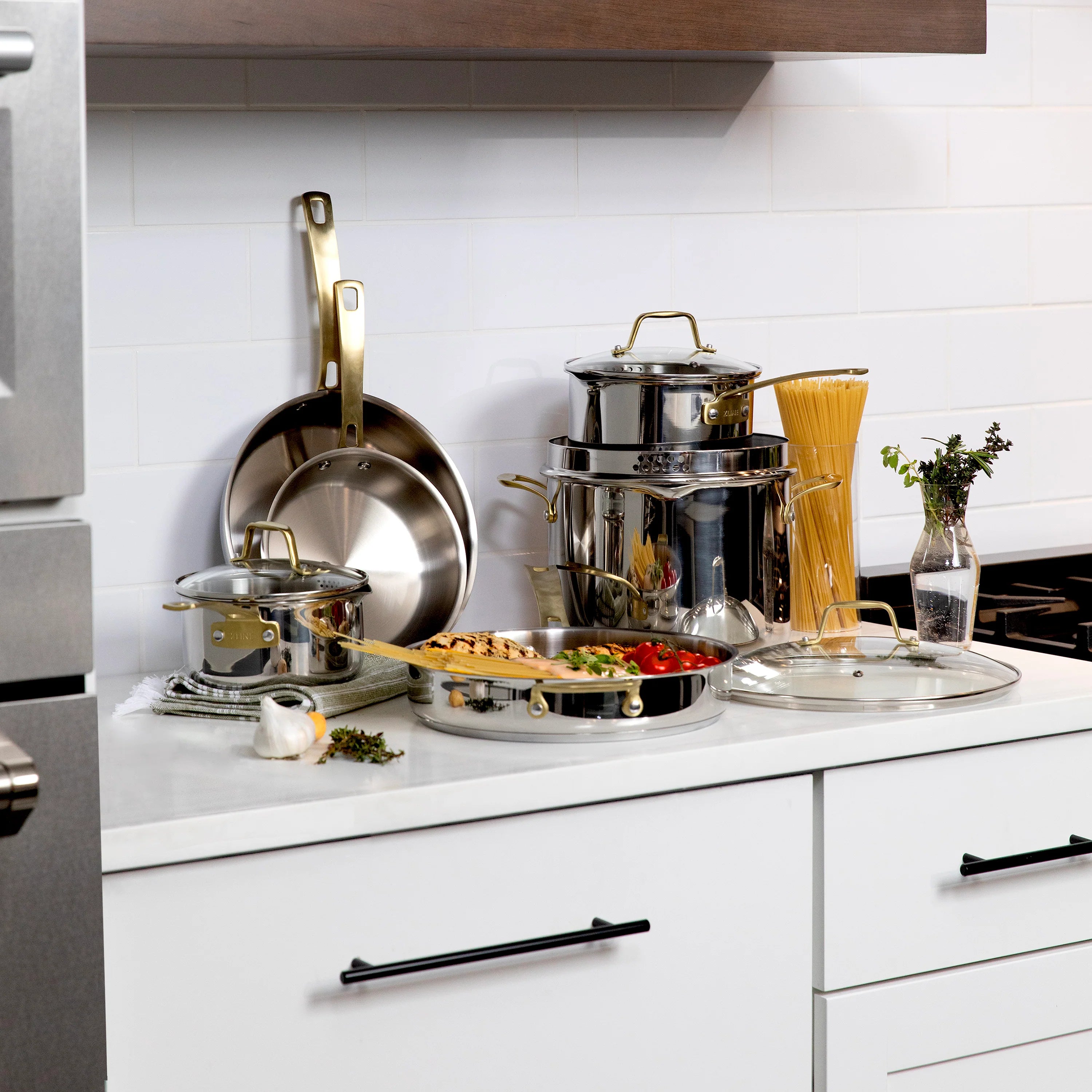 Stainless steel cookware set with covered pot, pan, and utensils