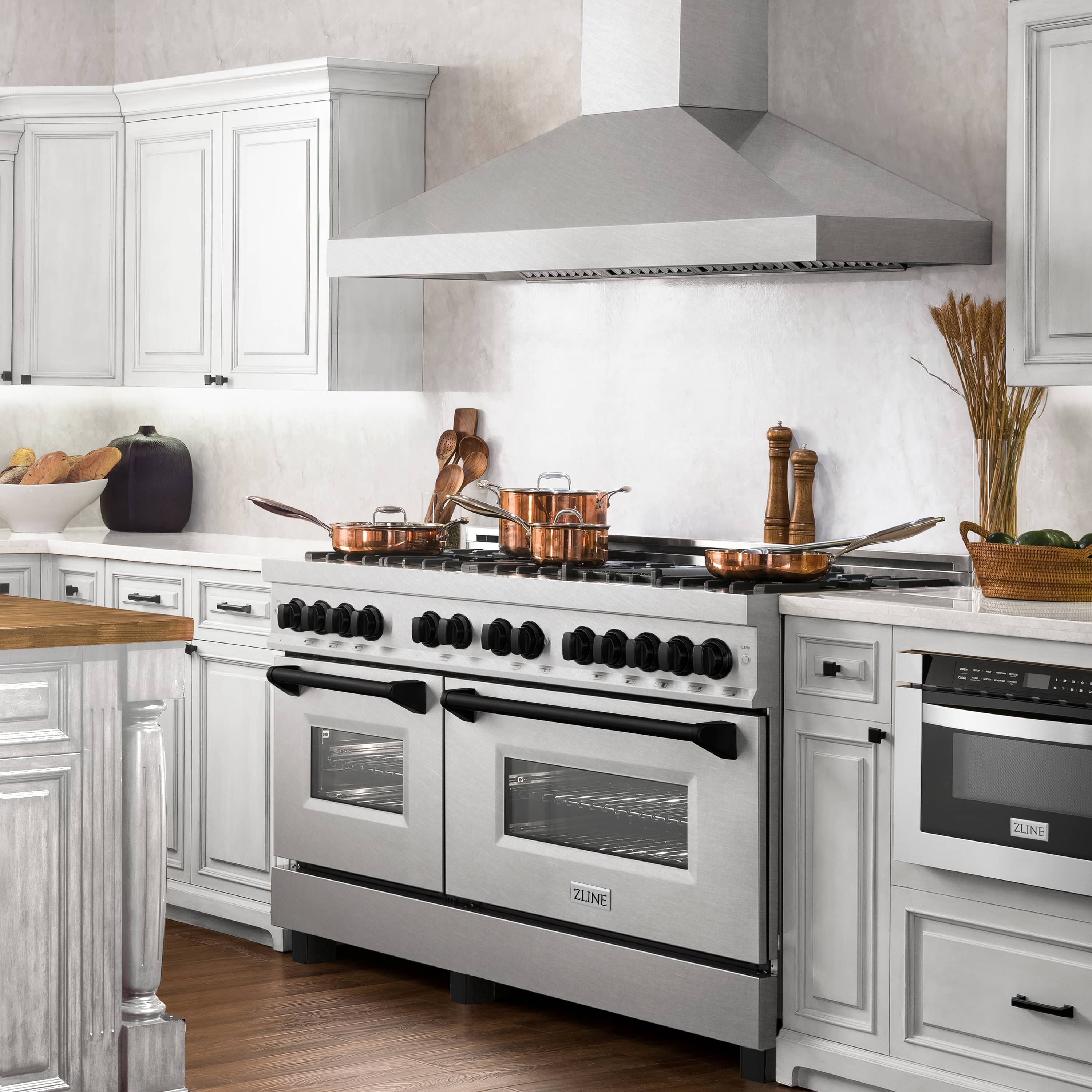 Dual fuel range in satin stainless steel with black knobs, oven doors, and side backsplash