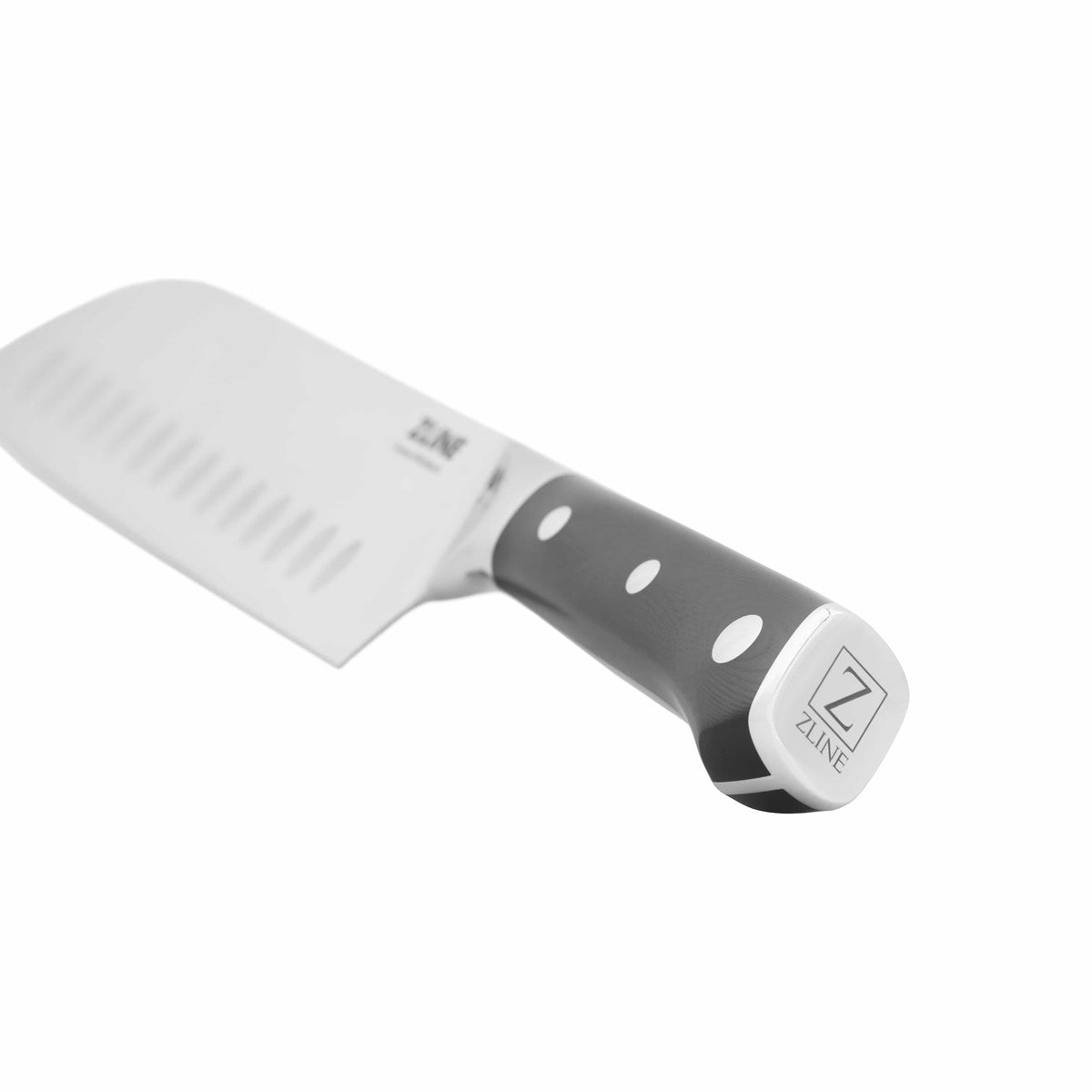Chef’s knife close-up: stainless blade with handle featuring white dot accents and bolster