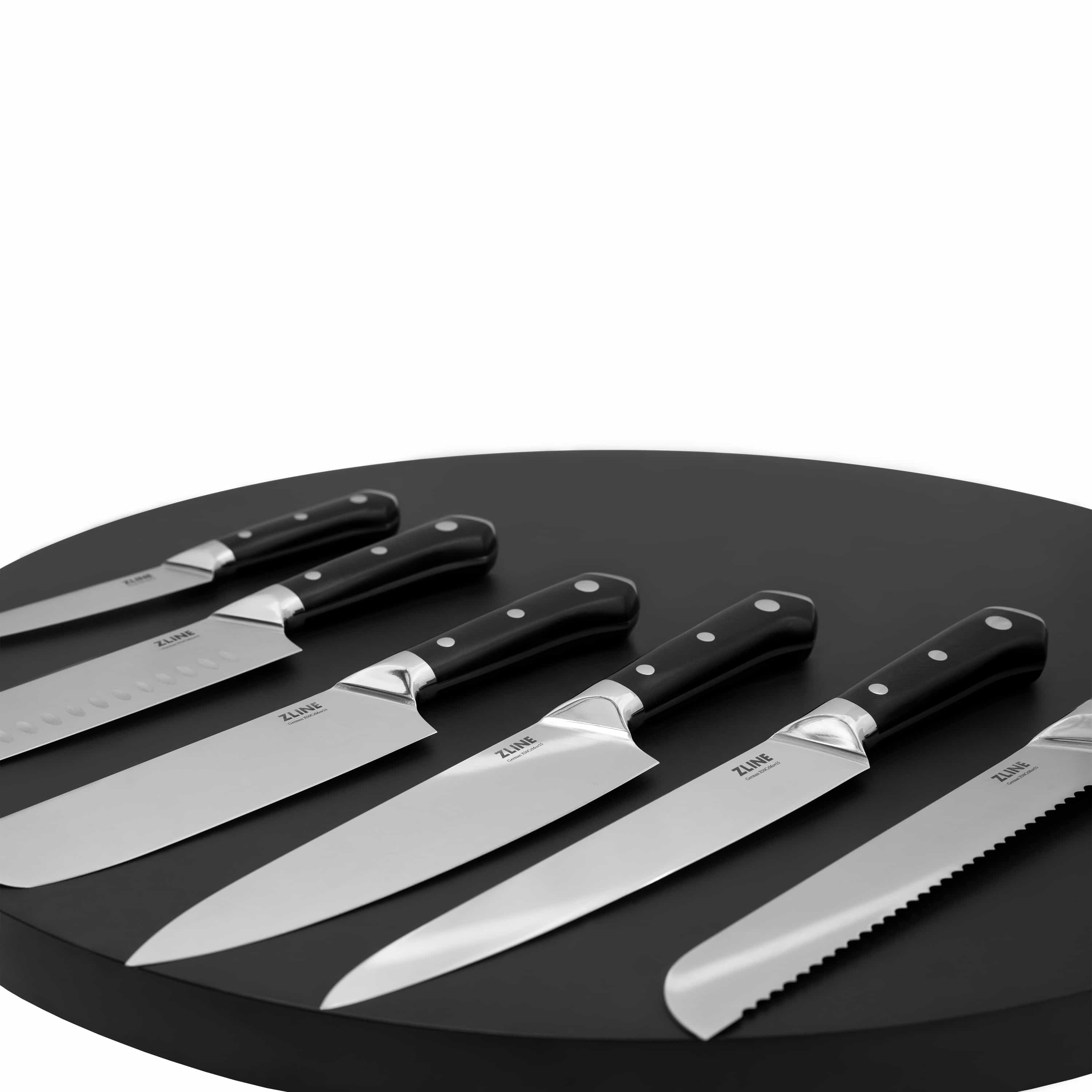 Set of kitchen knives with black handles and silver blades on dark tray