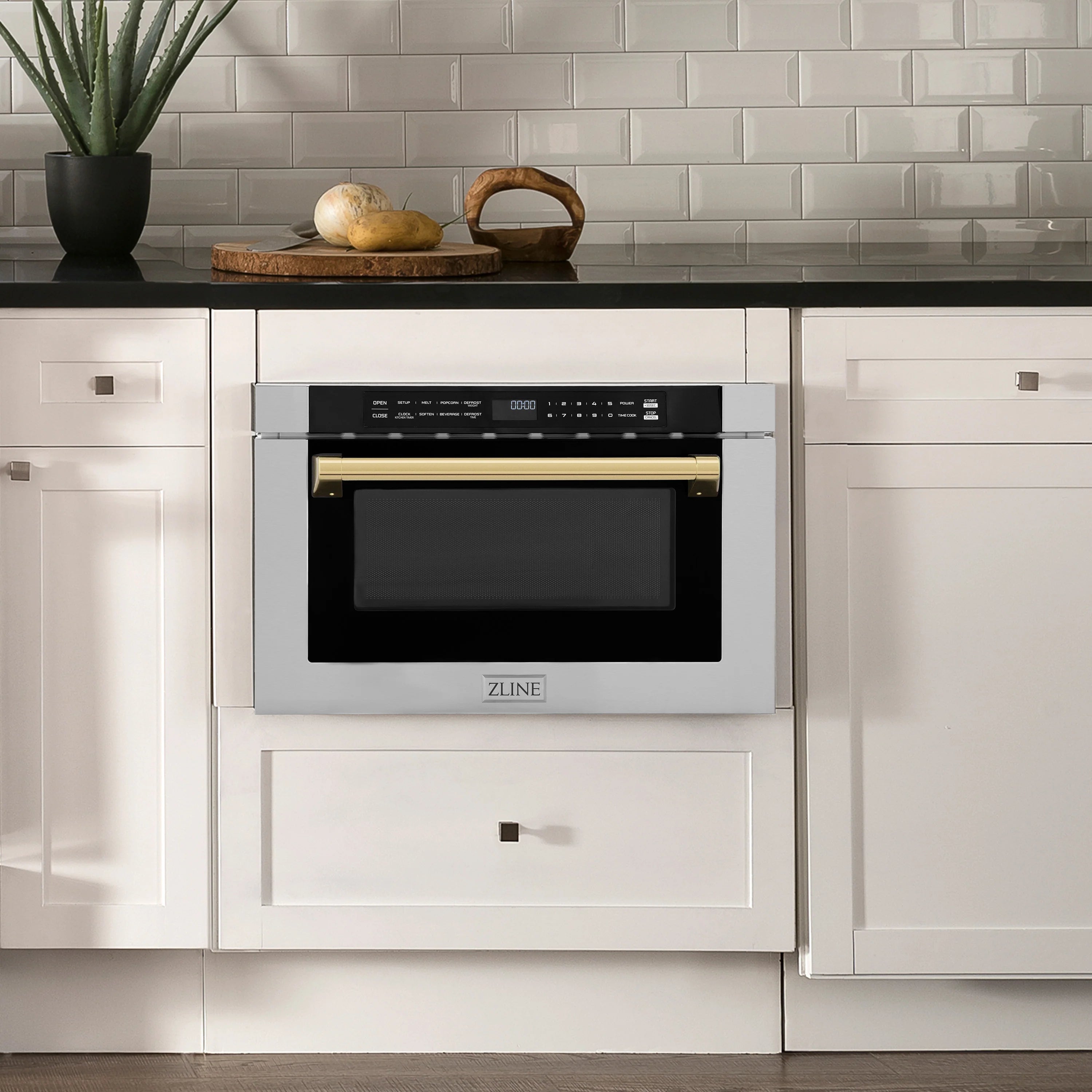 Stainless microwave drawer installed in cabinetry with black door and gold handle