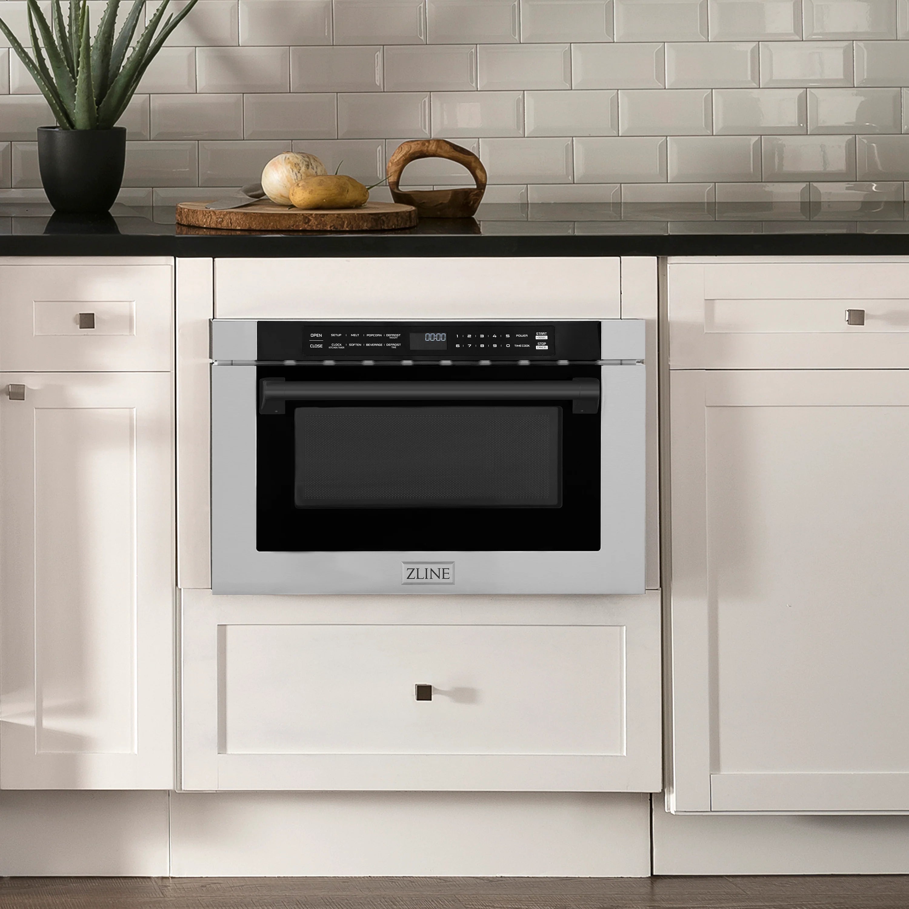 Built-in microwave drawer with stainless frame and black glass door in kitchen cabinet