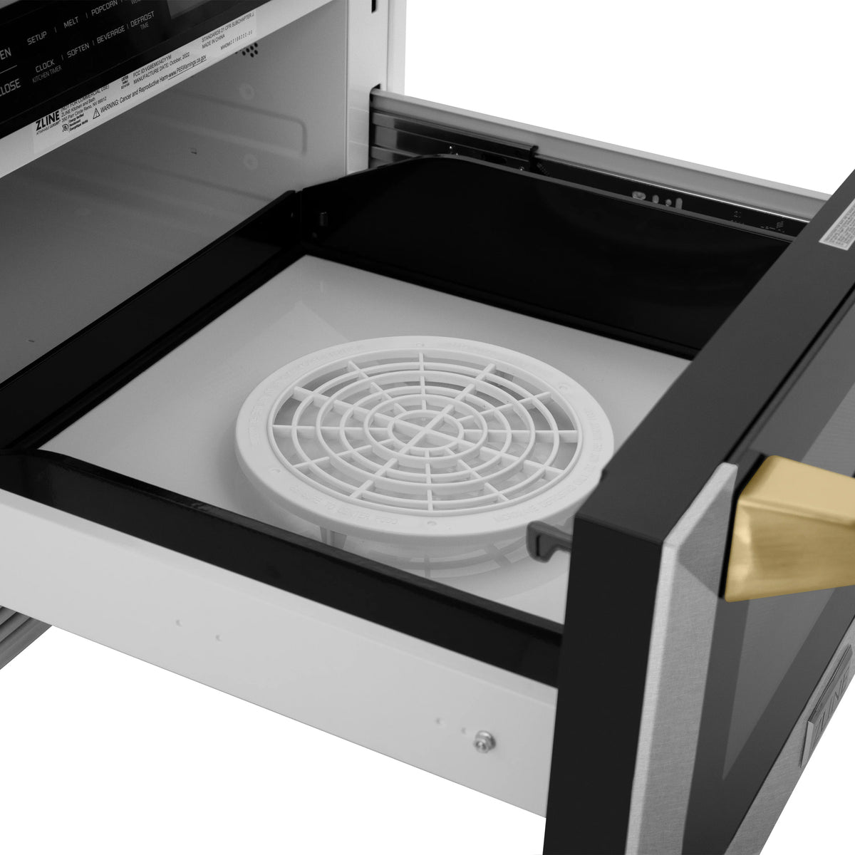 Microwave drawer interior with white turntable plate and gold-accent handle