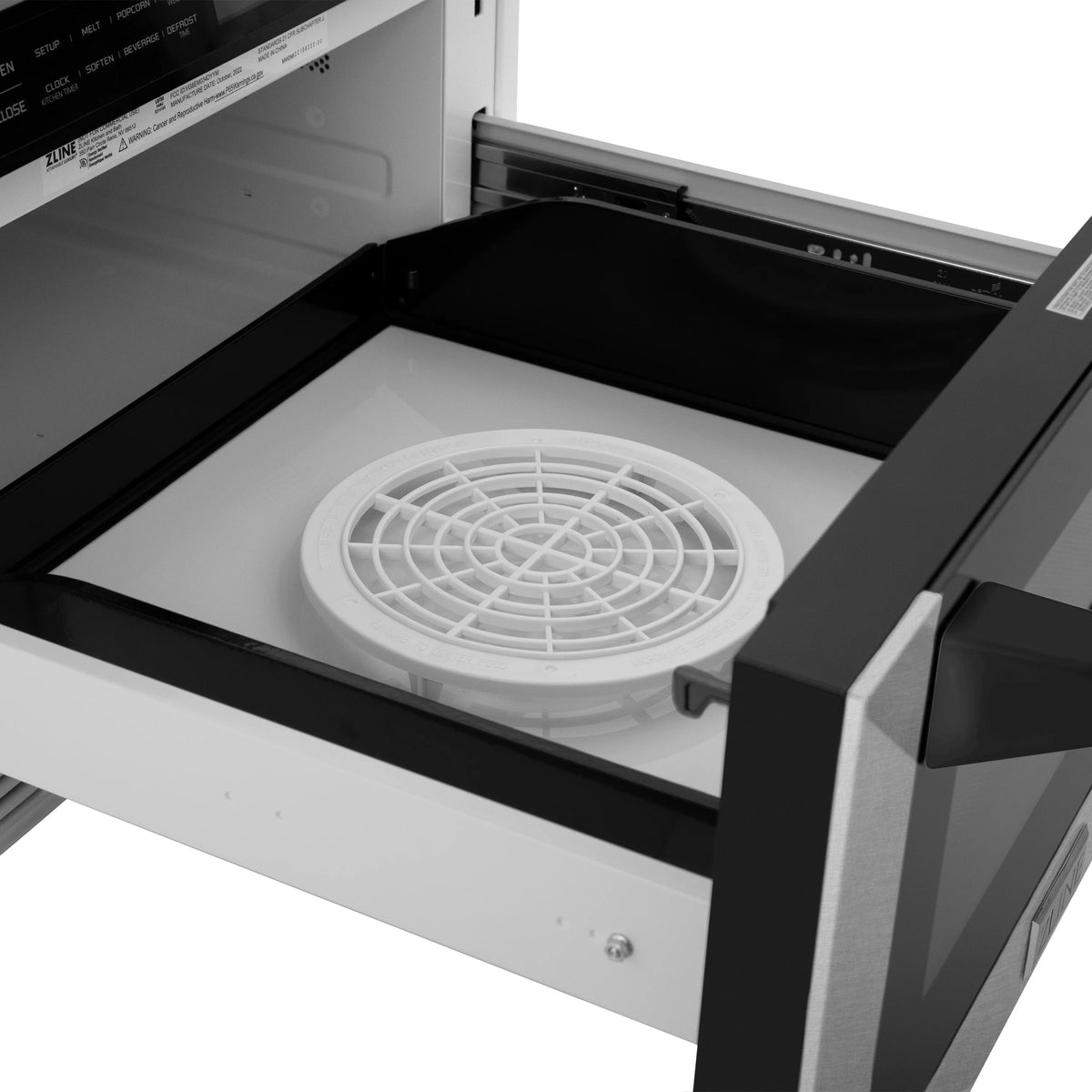 Open microwave drawer with white circular turntable and black side rails