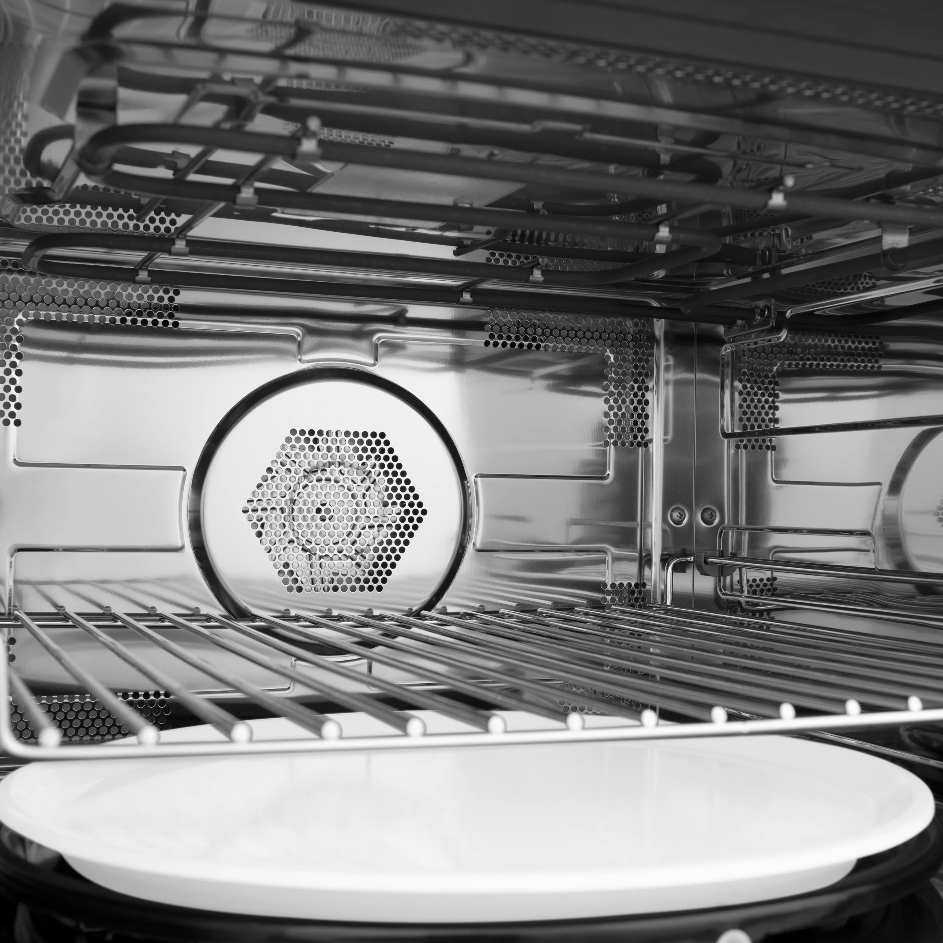 Interior of convection microwave oven with glass turntable and metal racks