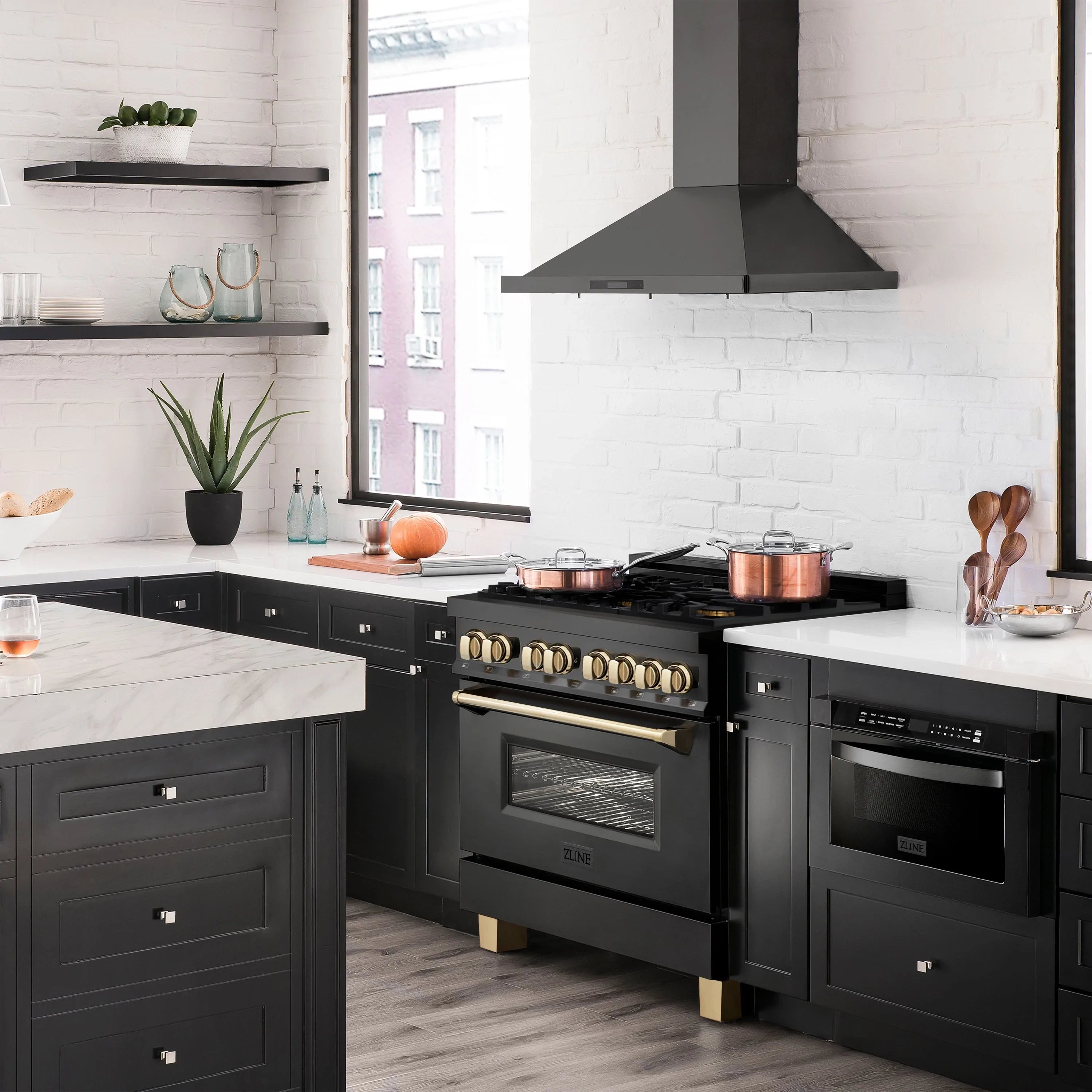 Black dual fuel range in kitchen with gold knobs and oven window