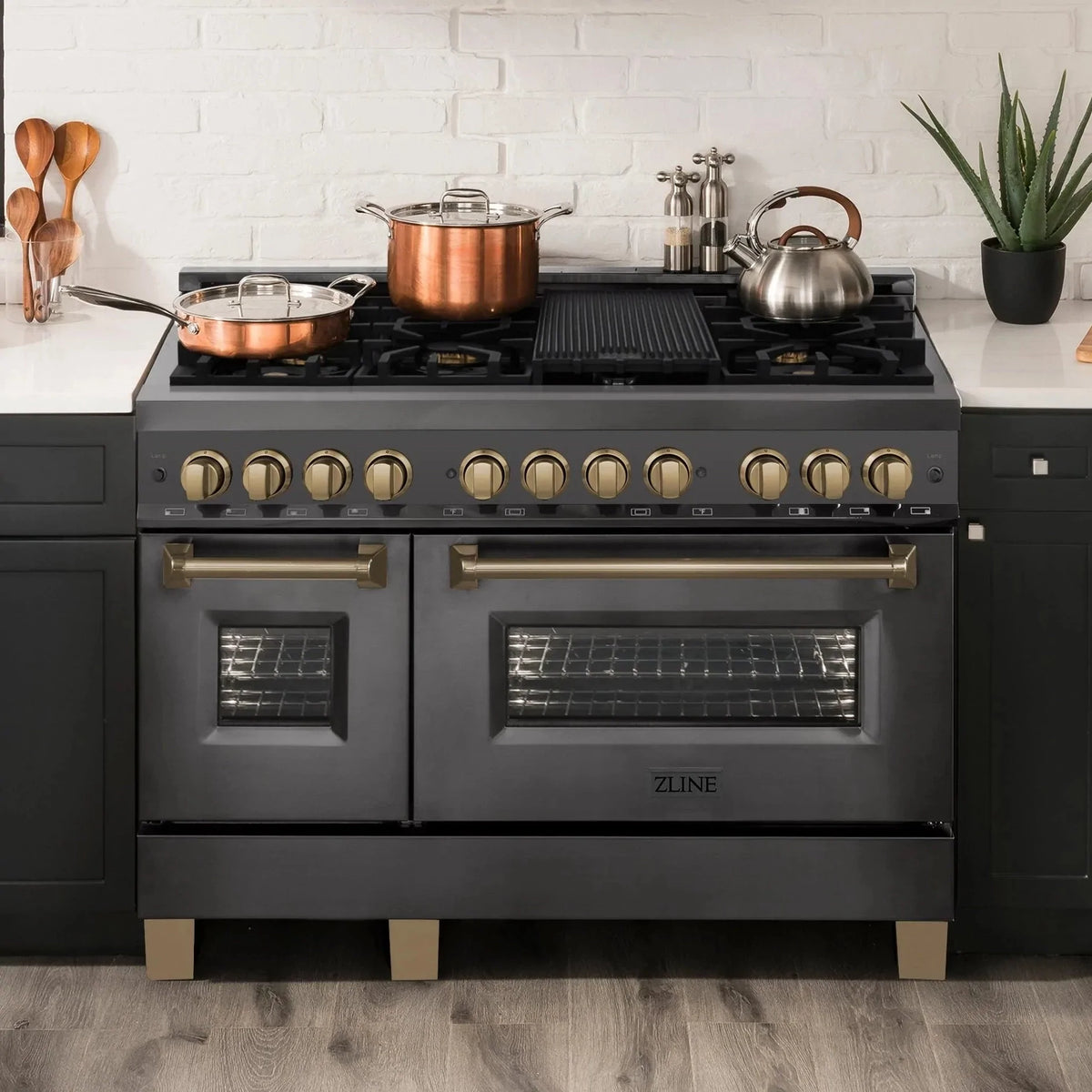 Black dual-fuel range with dual open oven doors and champagne bronze accents