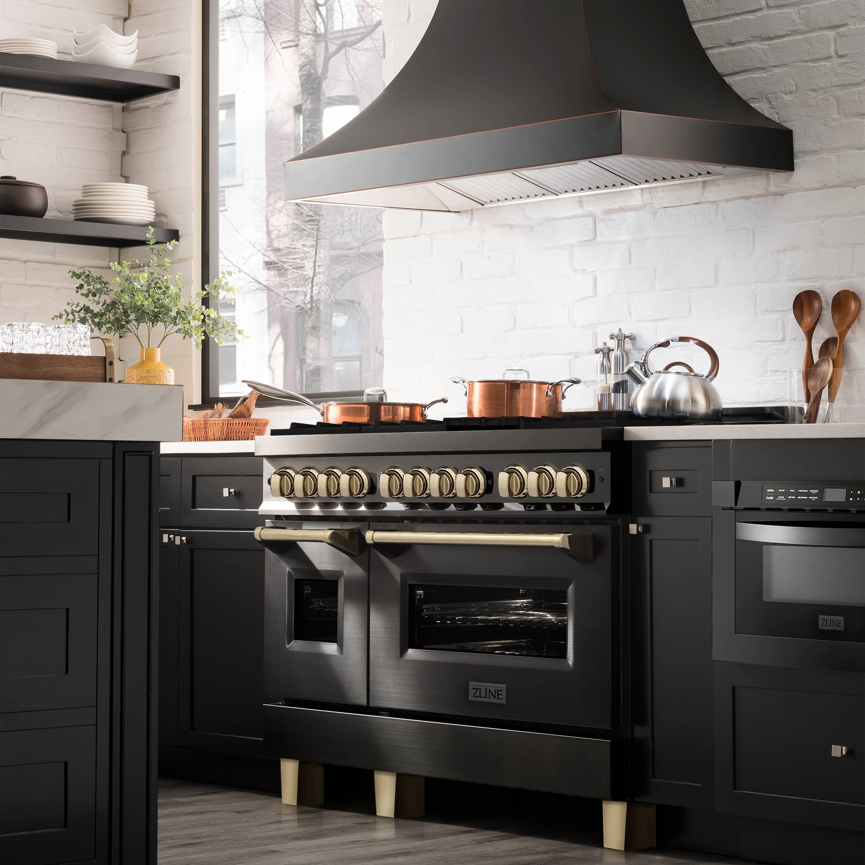 Black dual fuel range with gold knobs, gas burners, and electric oven doors
