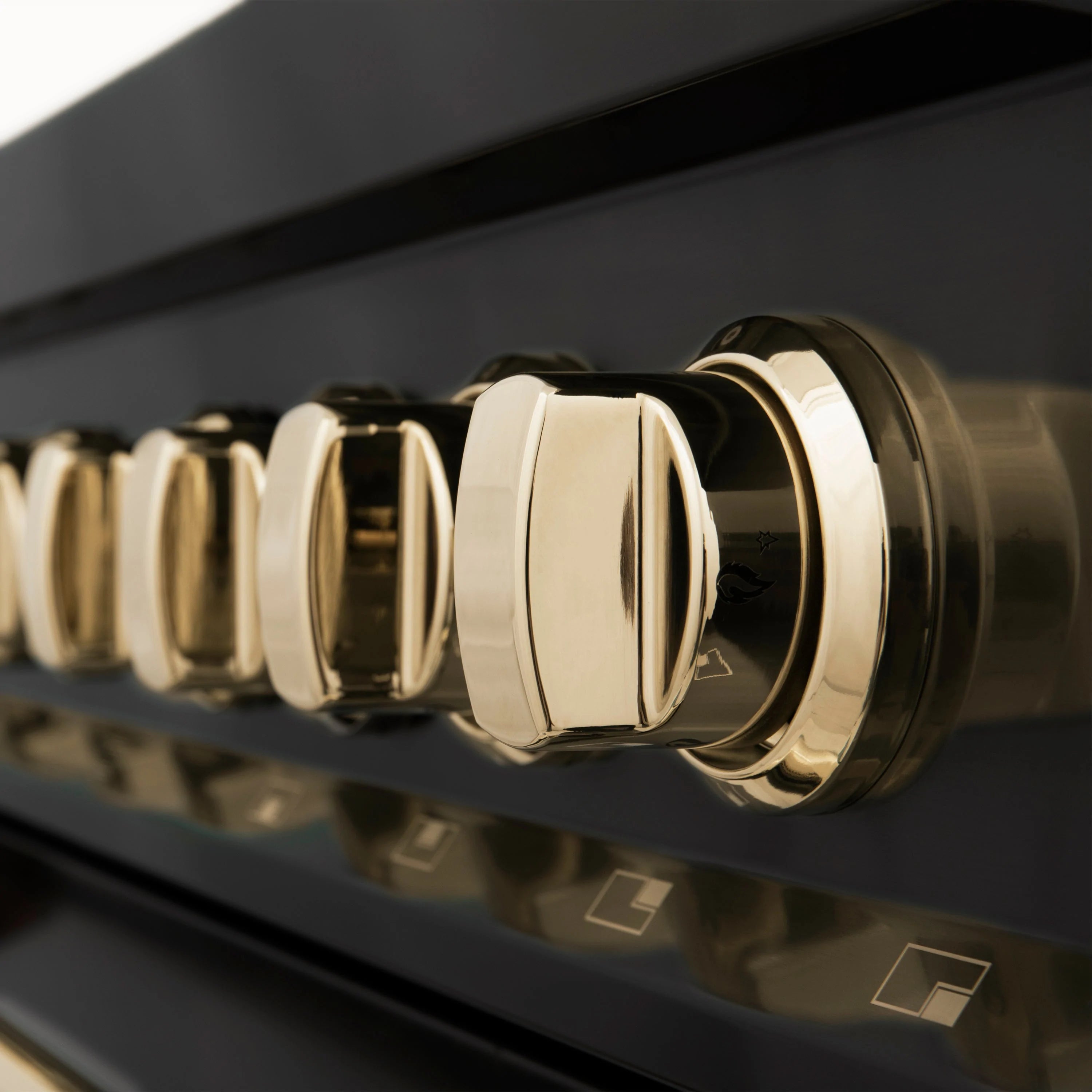 Gold control knobs on a black range front panel