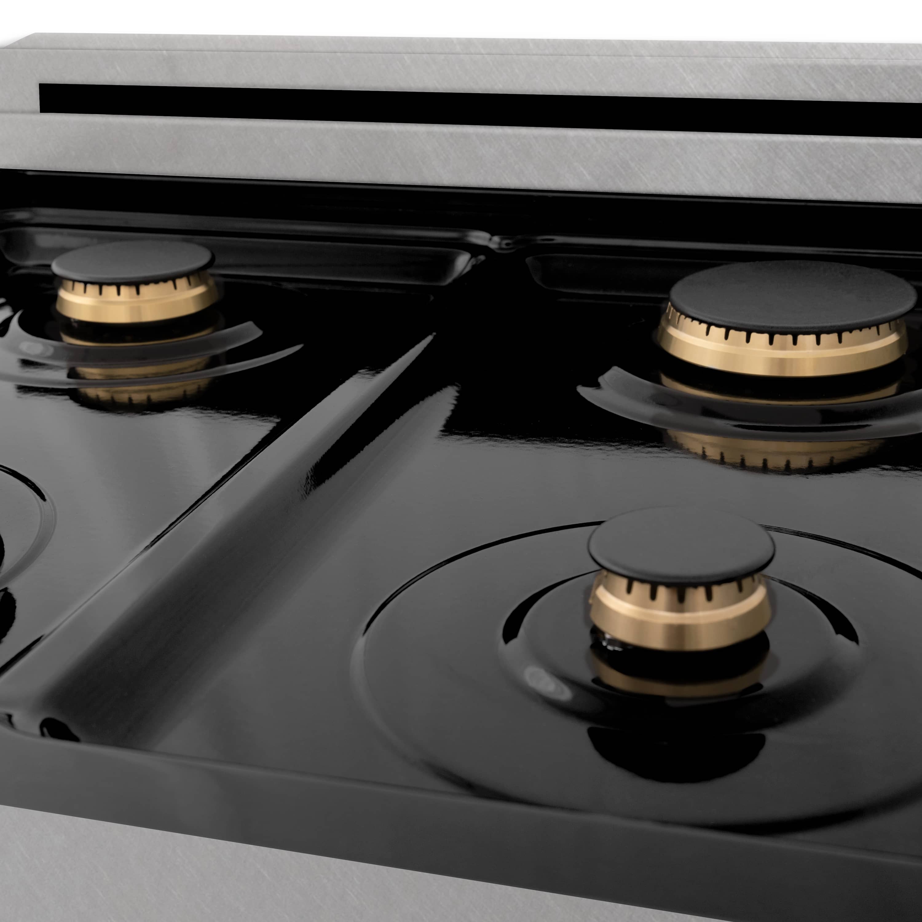Close-up of black cooktop with round burner caps and brass rings