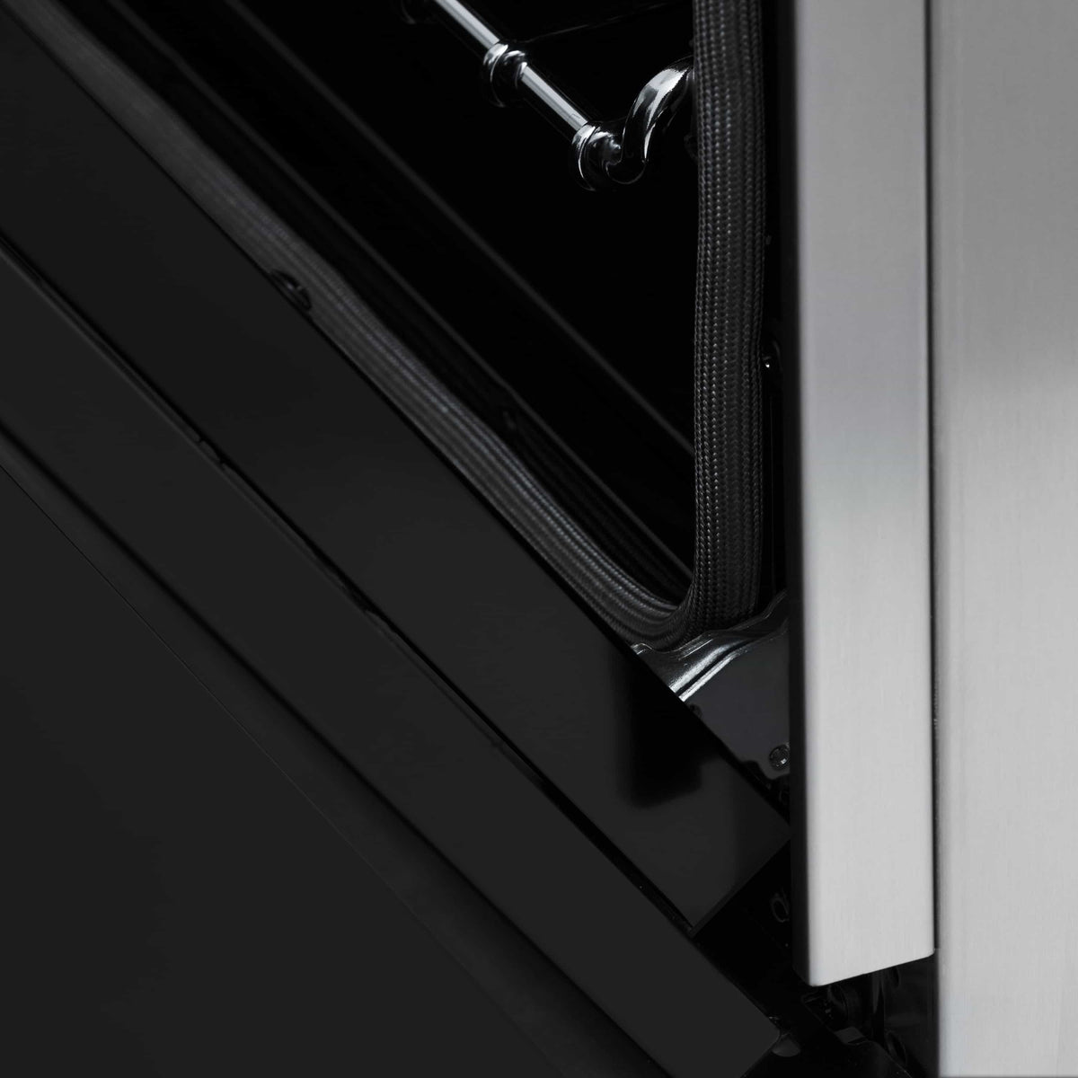 Black drawer-style panel beneath the oven door on a stainless range