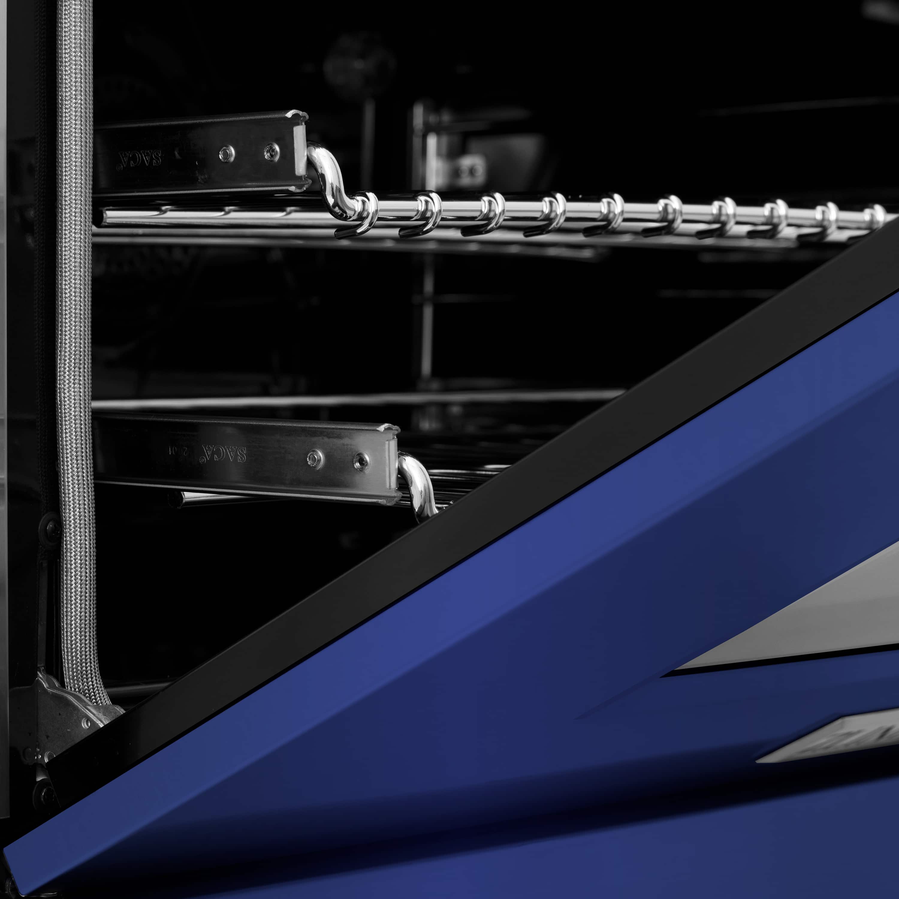 Open oven door showing metal racks and blue matte inner panel