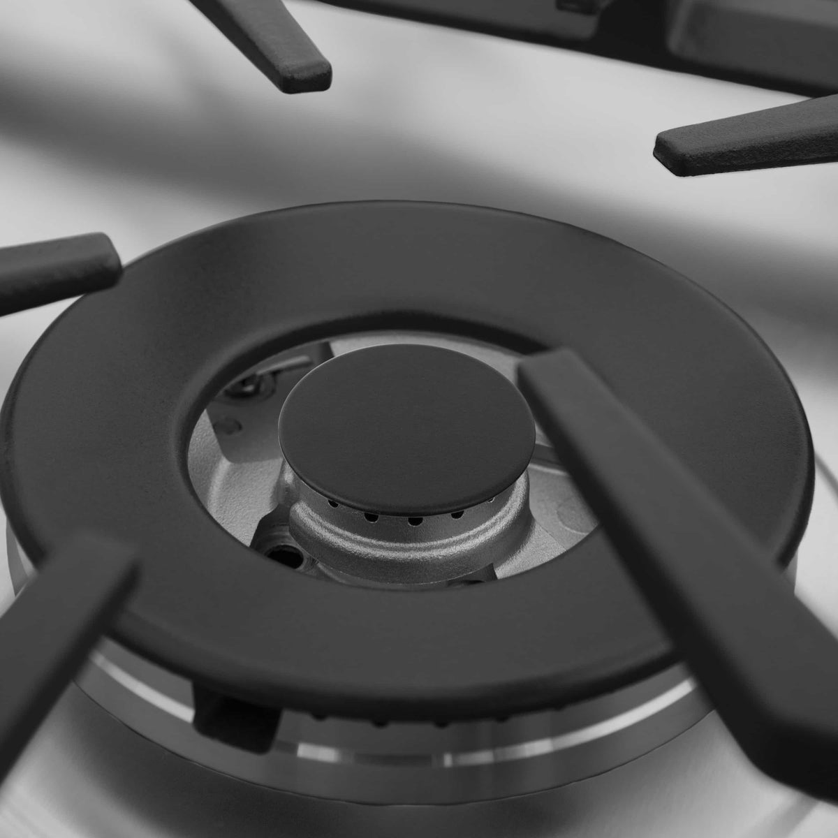 ZLINE gas cooktop burner with black cap and circular grate over silver burner ring