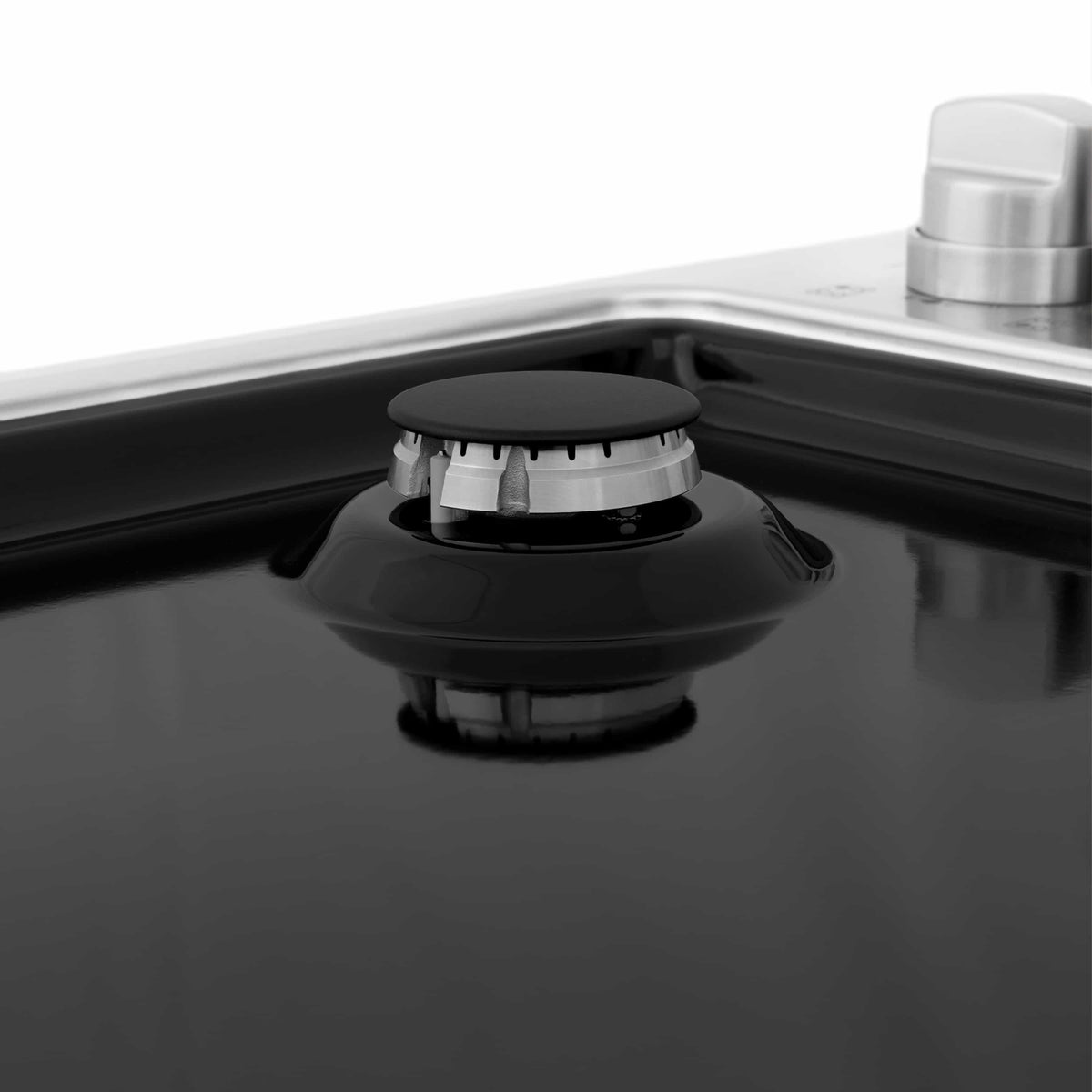 Black gas burner on ZLINE black porcelain cooktop with a metal control knob