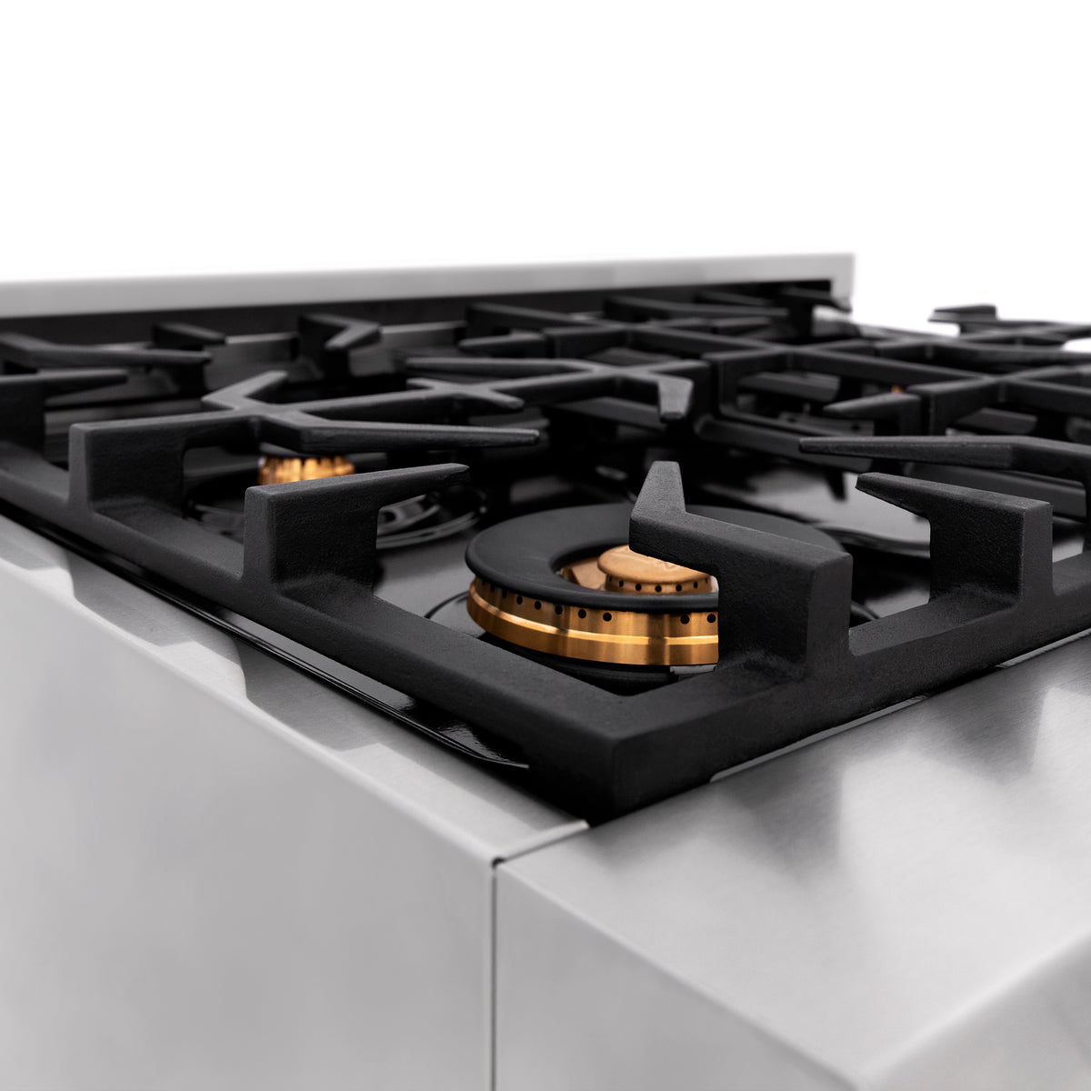 Stainless gas cooktop with black grates and brass burner cap