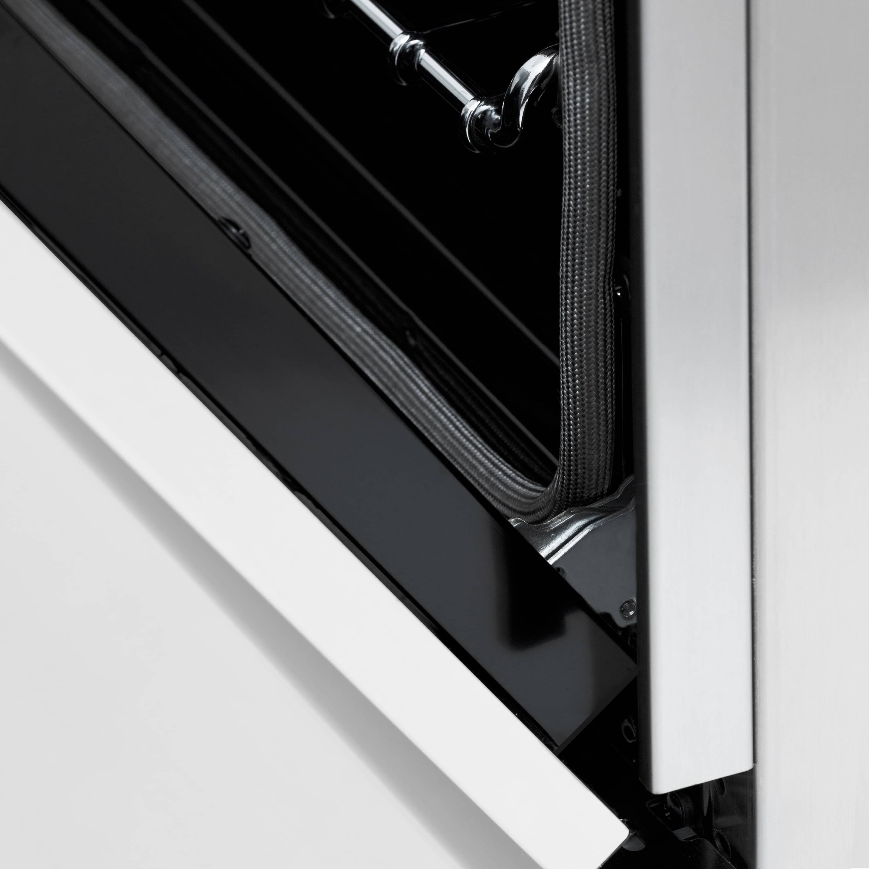 Close-up of the oven door edge with black gasket and chrome rack rails