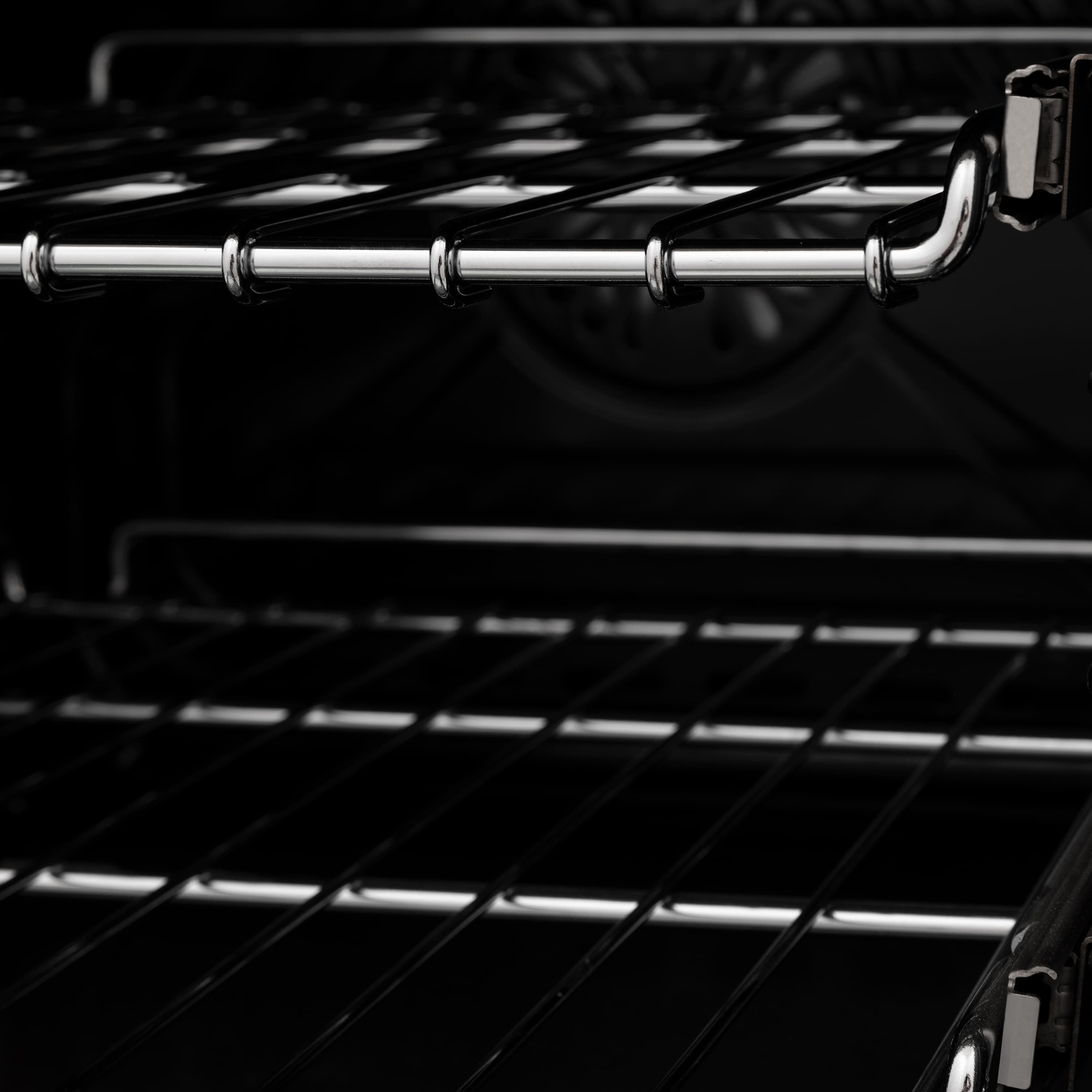 Dual fuel range oven interior with black racks and chrome heating elements