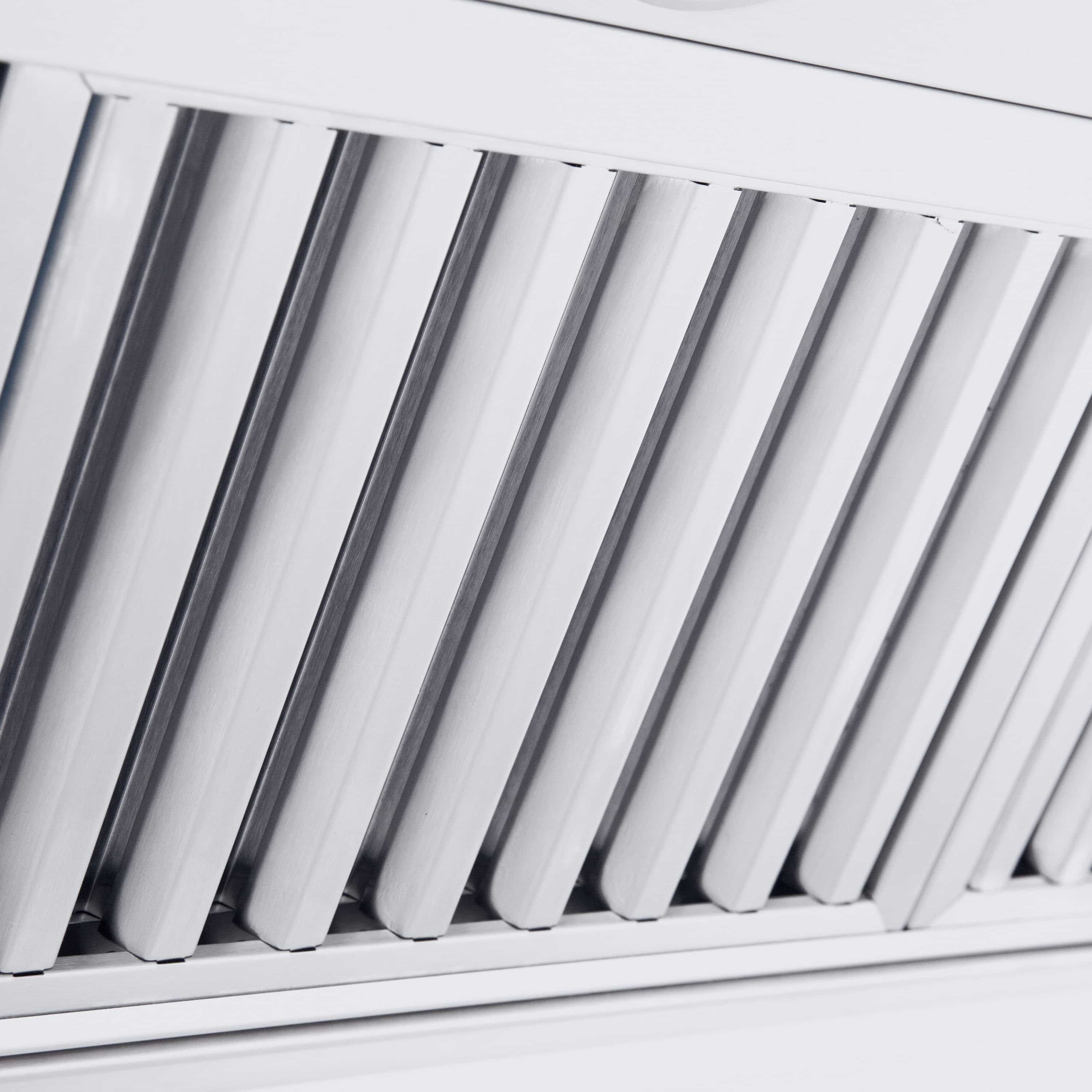 Stainless steel vent hood with vertical grille louvers beneath the canopy