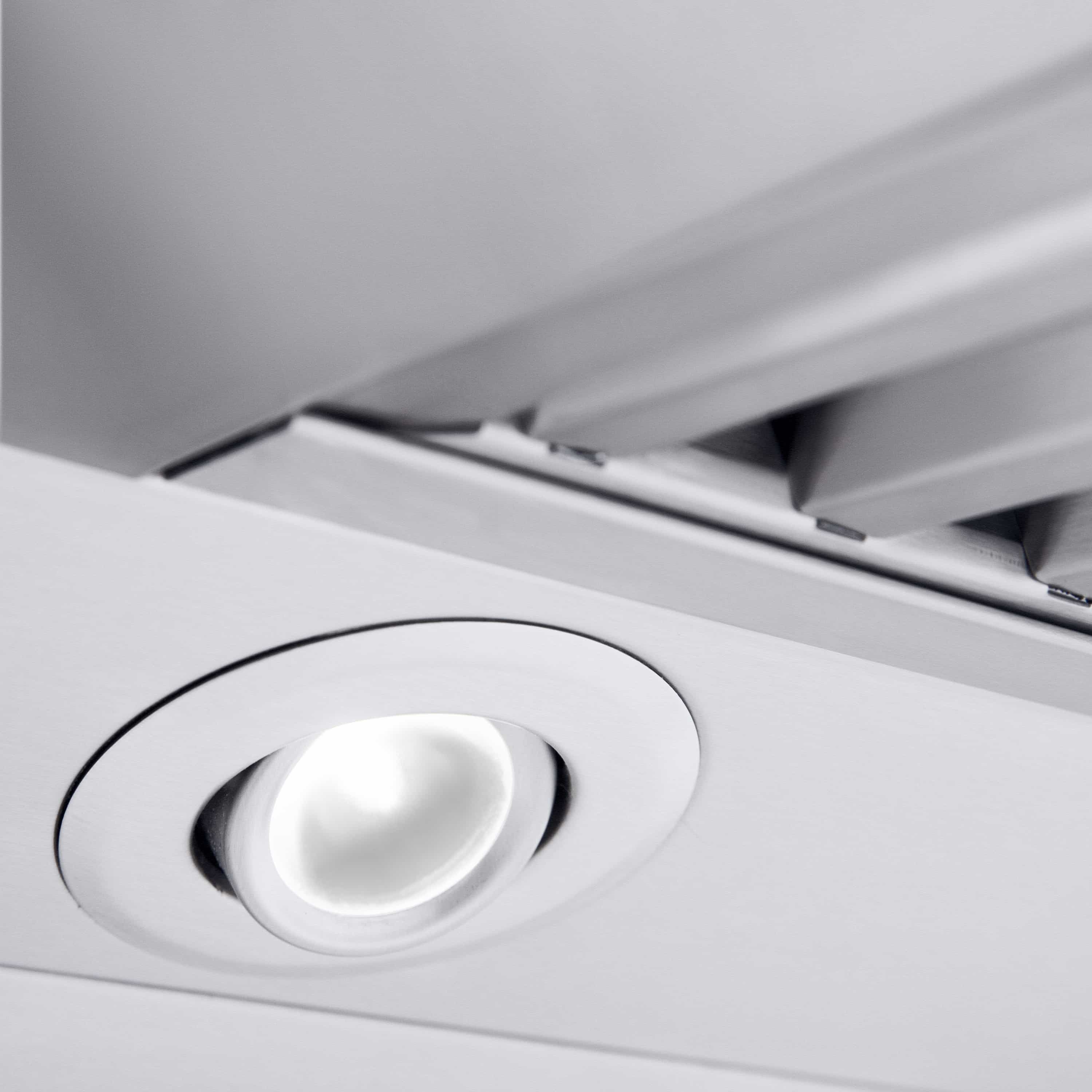 Recessed round spotlight in stainless steel range hood ceiling panel