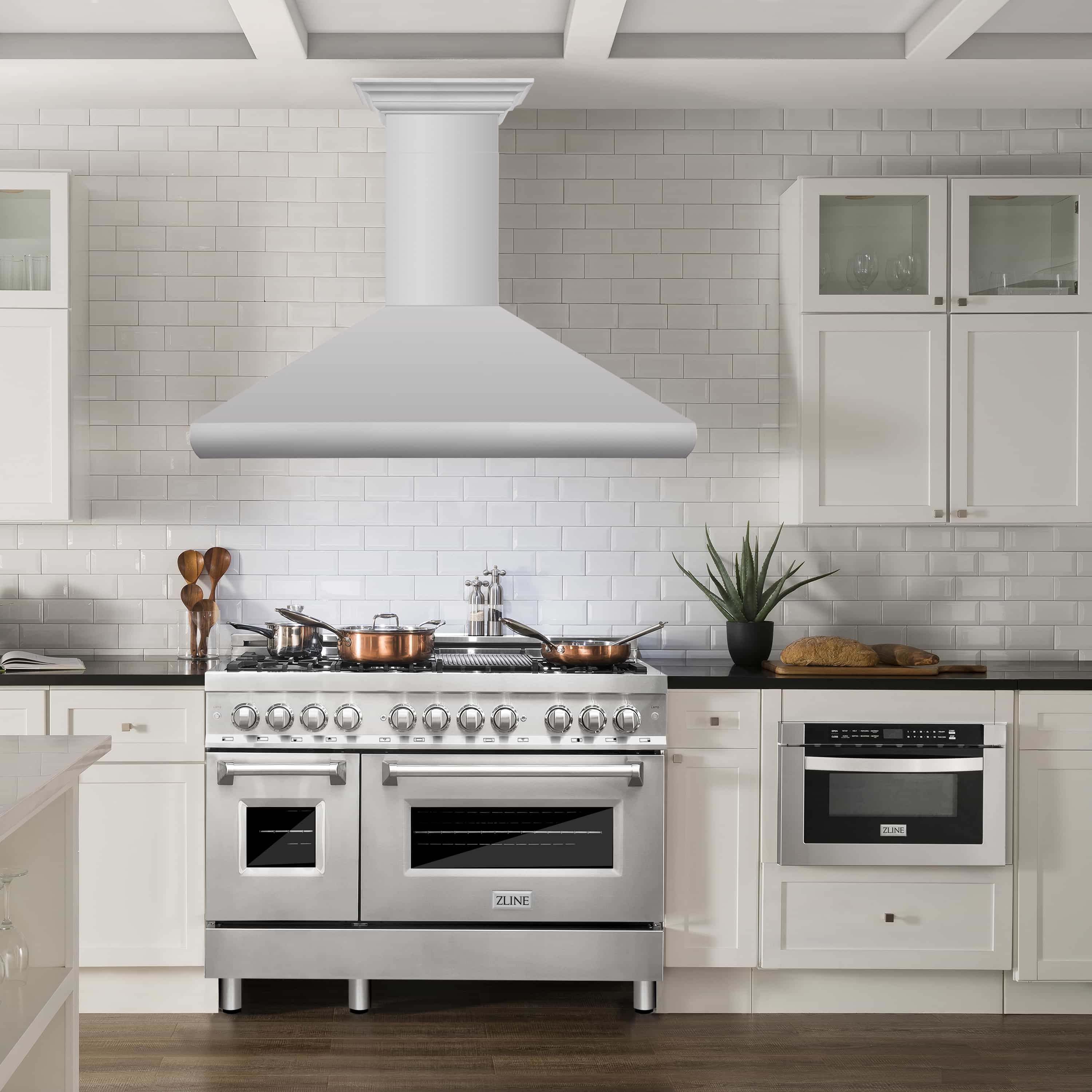 Light-colored wall-mount range hood centered above a kitchen stove