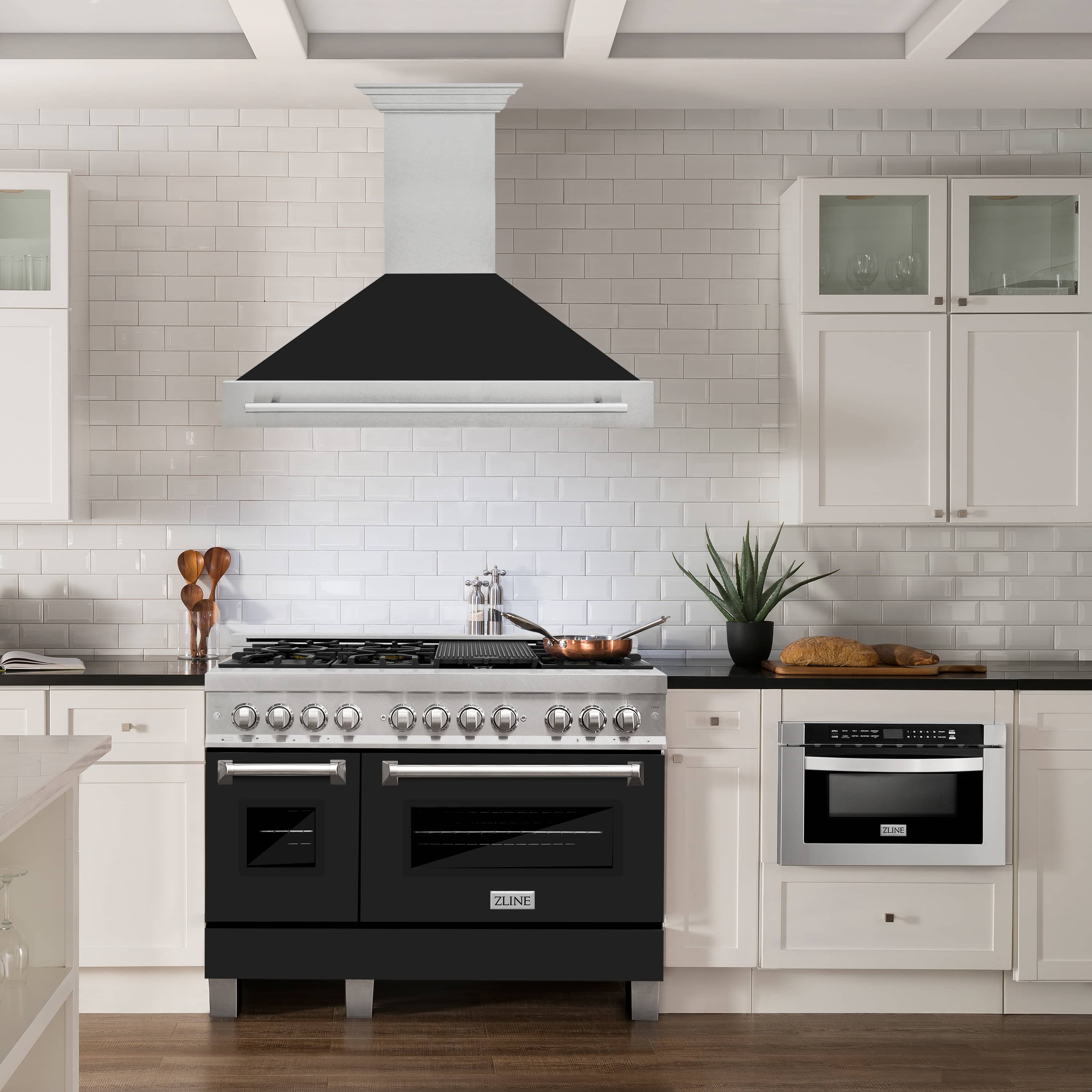Wall-mount range hood with black baffle canopy and satin stainless chimney surround.