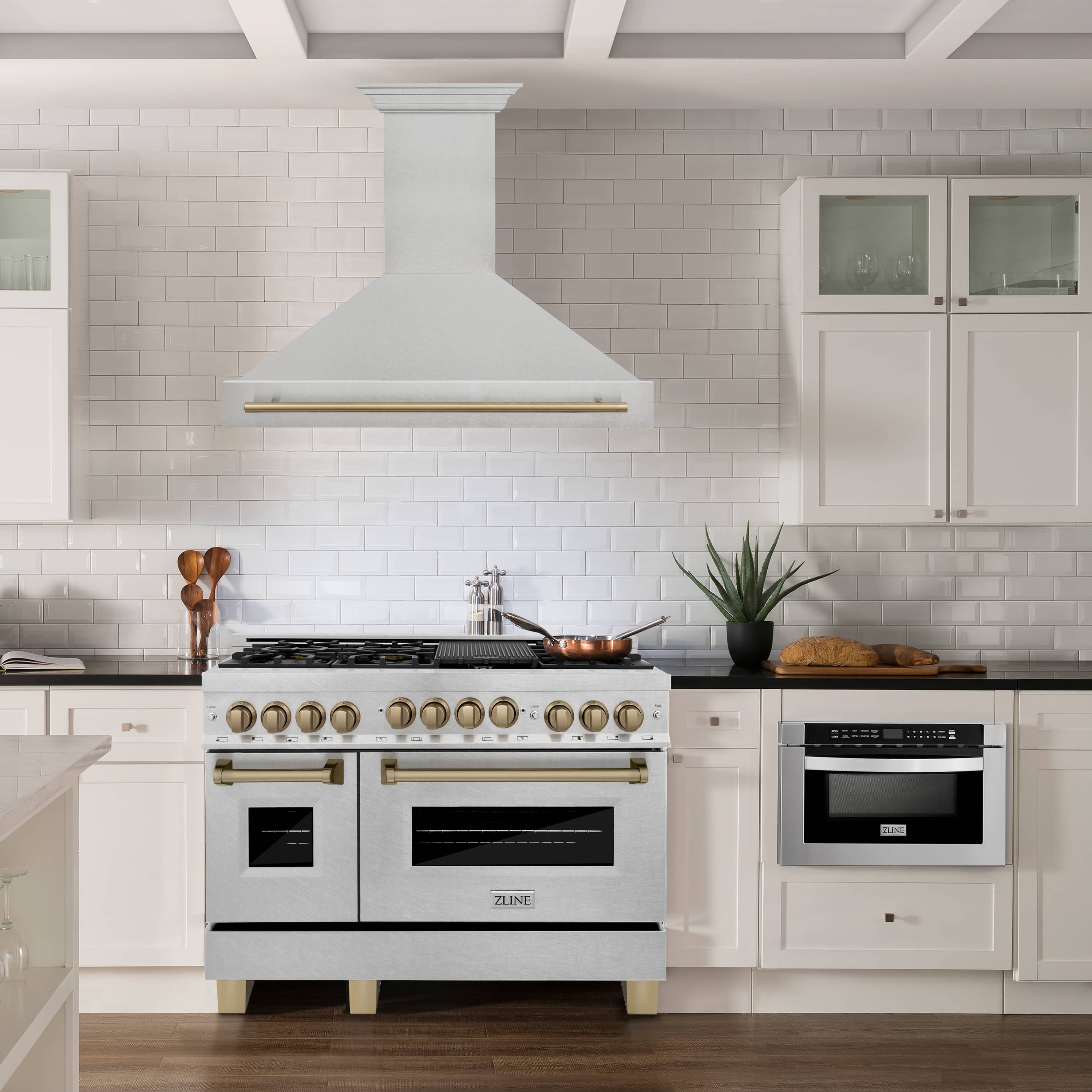 Wall mount range hood above a gas cooktop with satin stainless finish