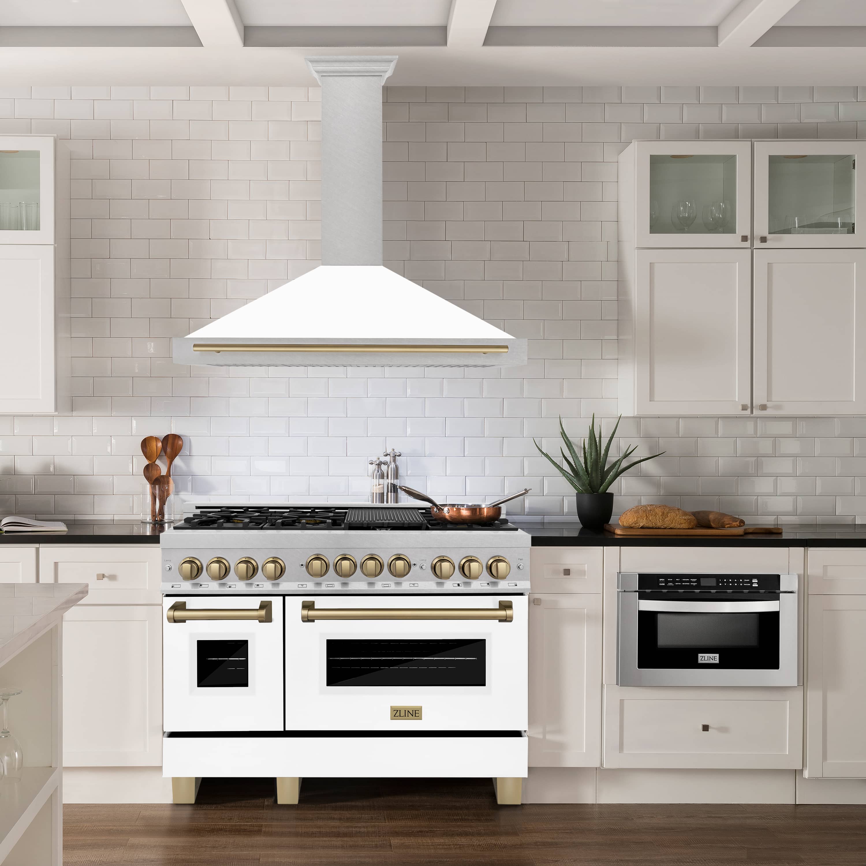 White range hood above stove with champagne bronze trim and stainless grille