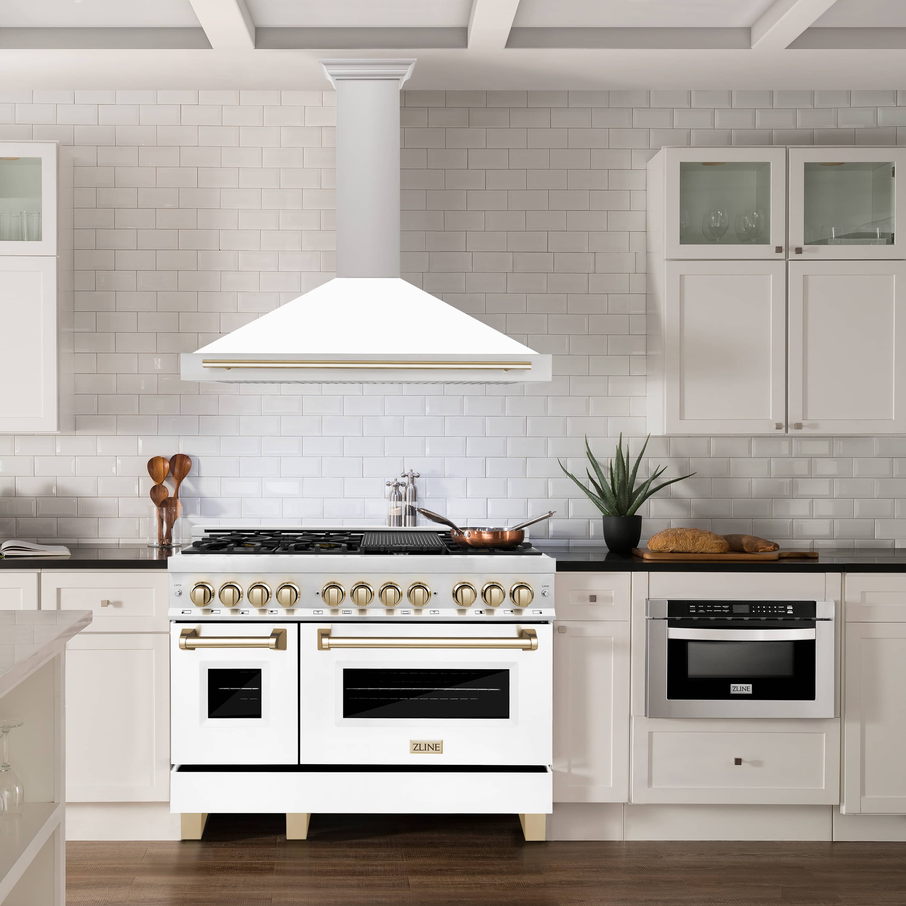 White wall-mounted range hood with gold accent strip and decorative front trim