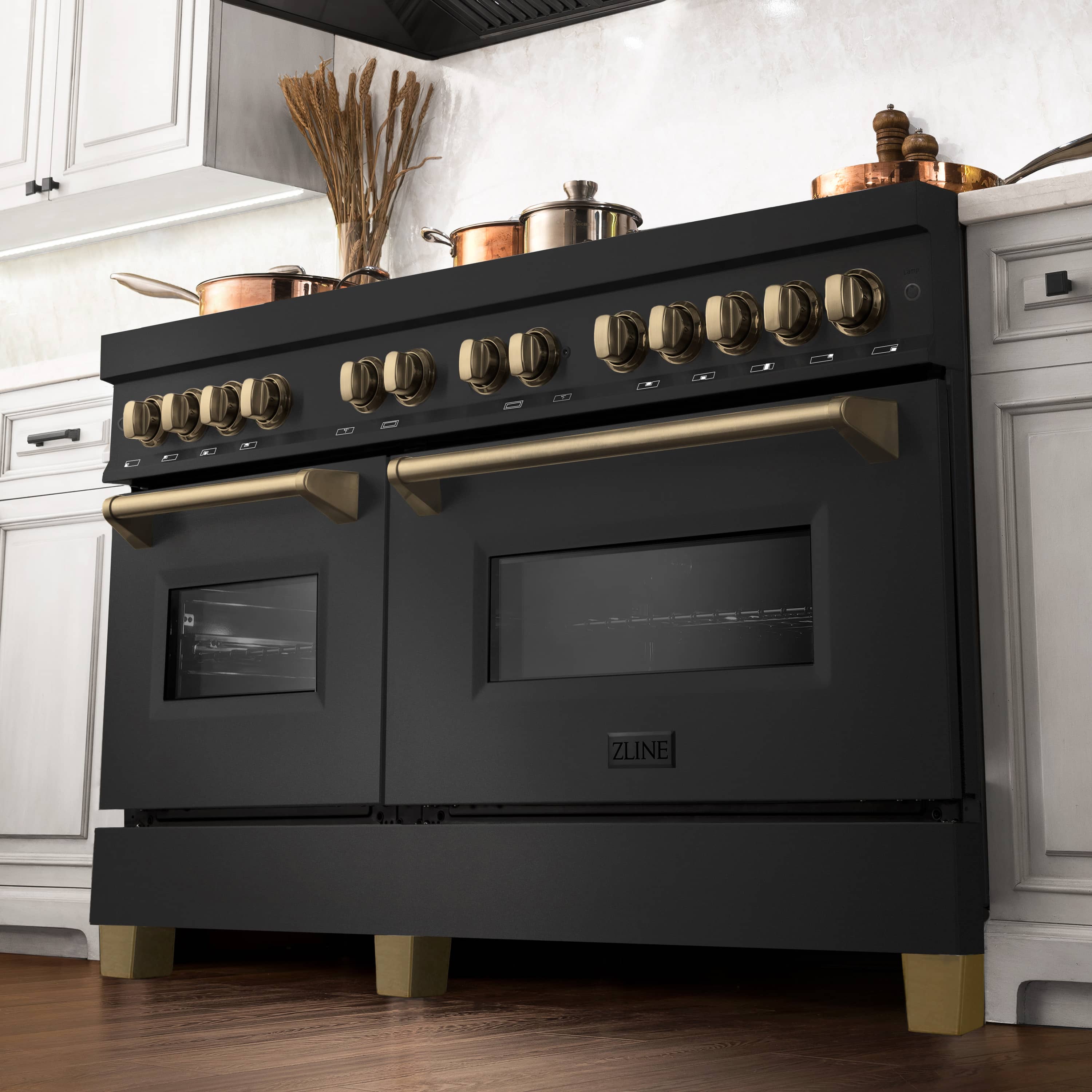 Black dual-fuel range with champagne-bronze knobs and front oven windows in a kitchen scene.