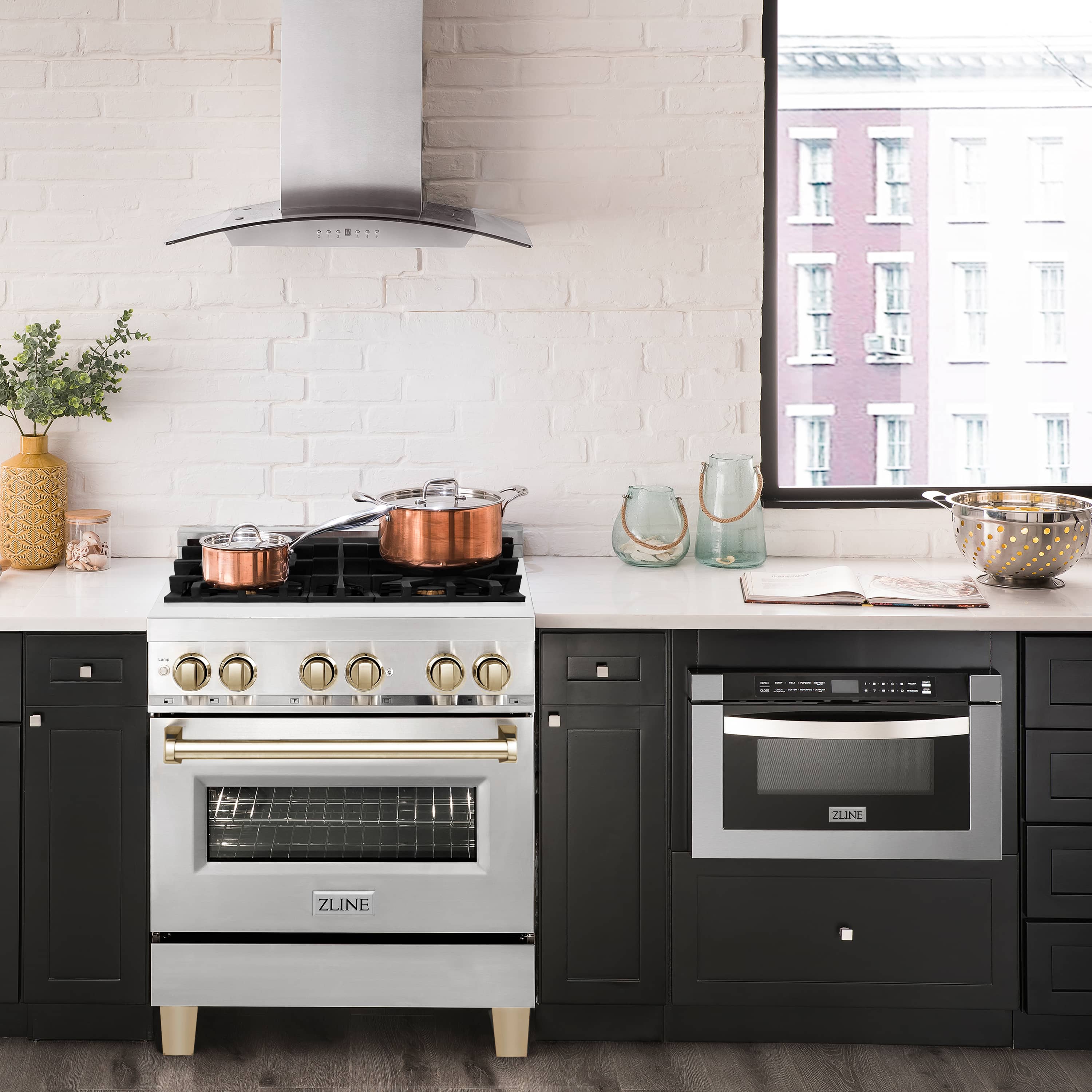 Stainless dual fuel range with gold knobs, black cooktop, and electric oven door