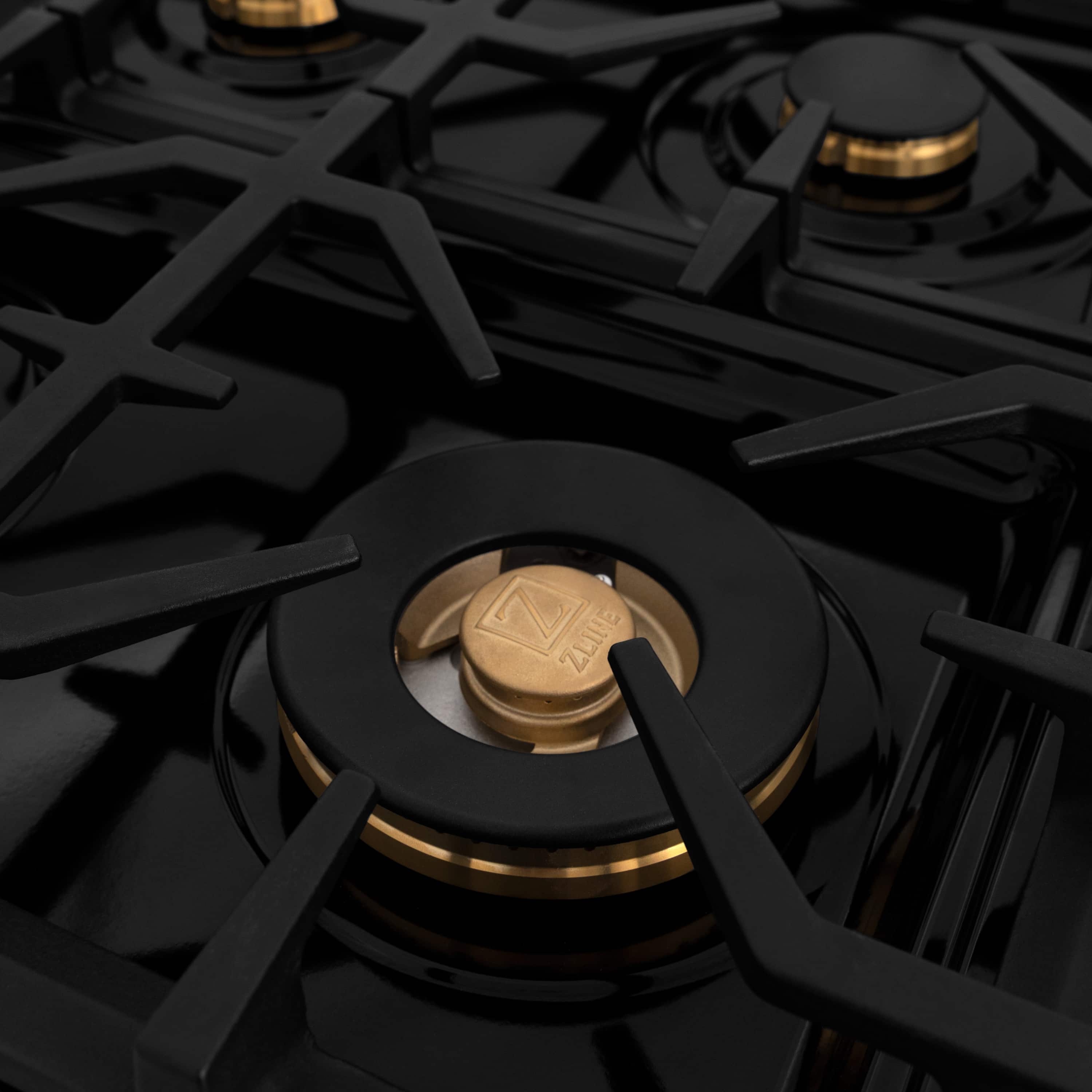 Single gas burner with black grate and gold center cap on dual fuel range