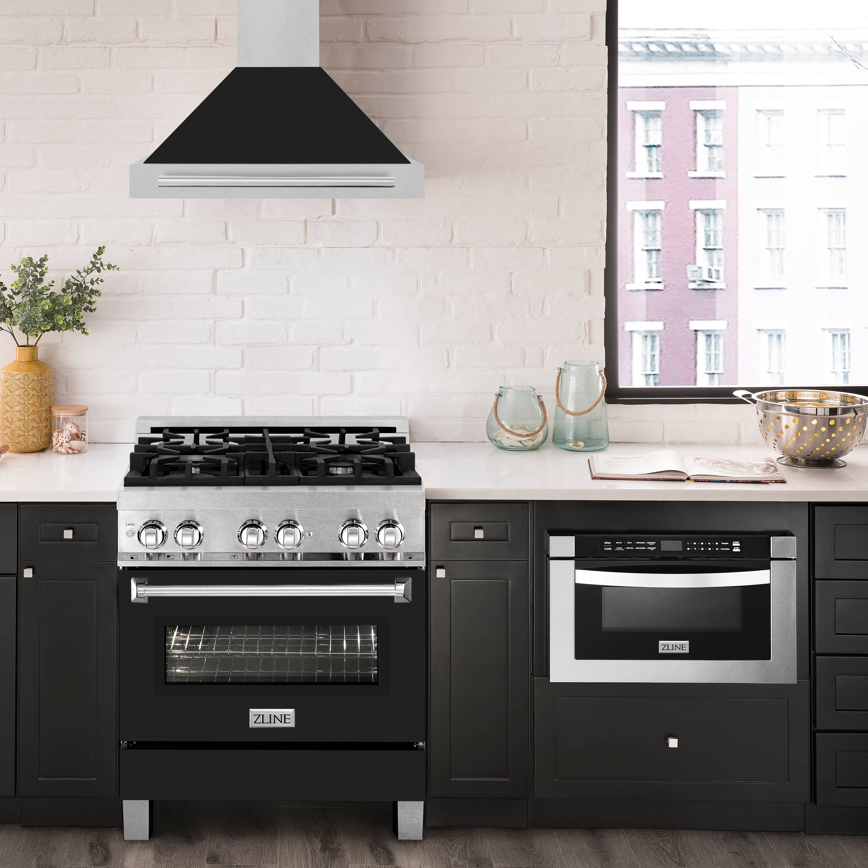 Wall-mounted range hood over cooktop, satin stainless chimney and black matte canopy