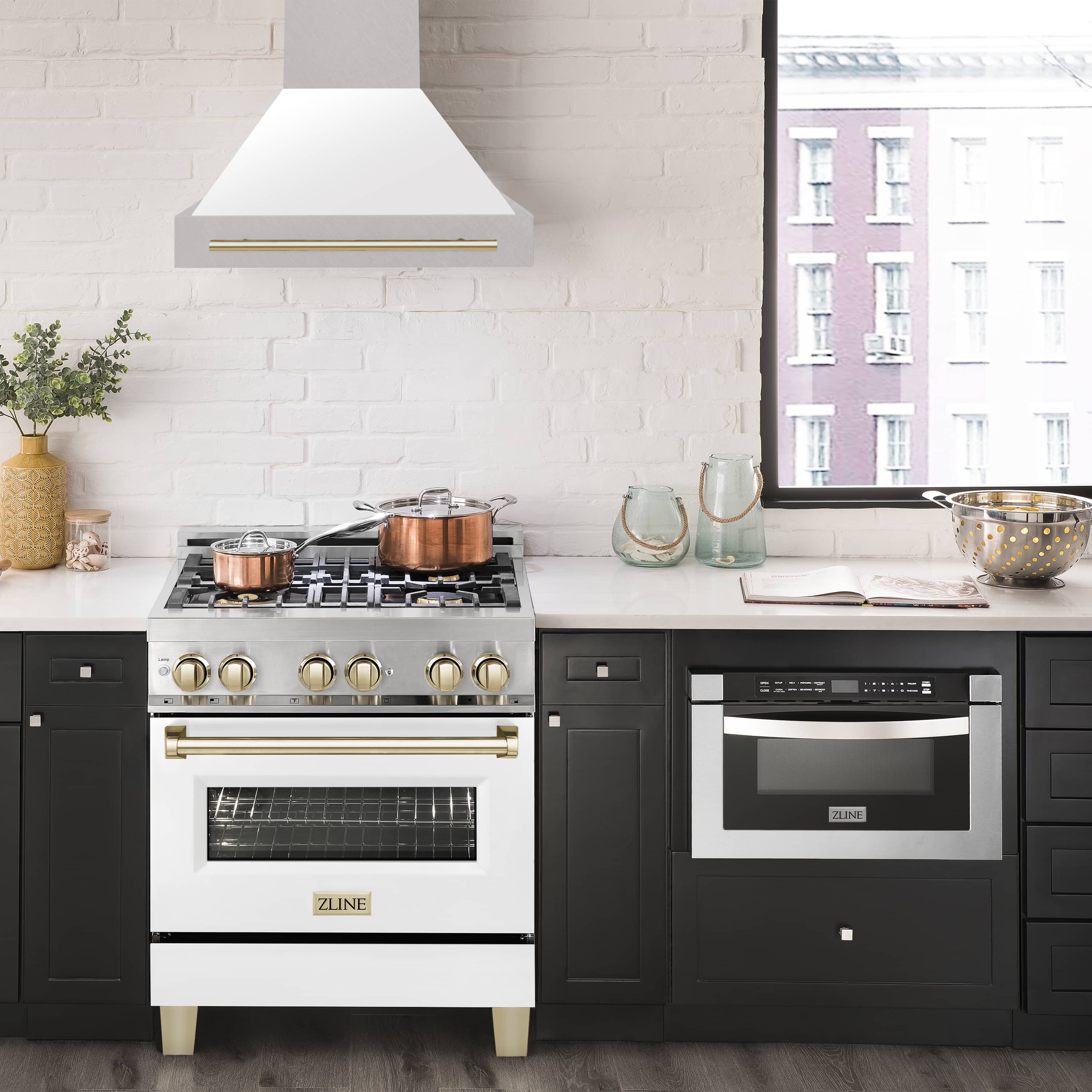 Wall mount range hood over black cooktop, white chimney with gold vent trim