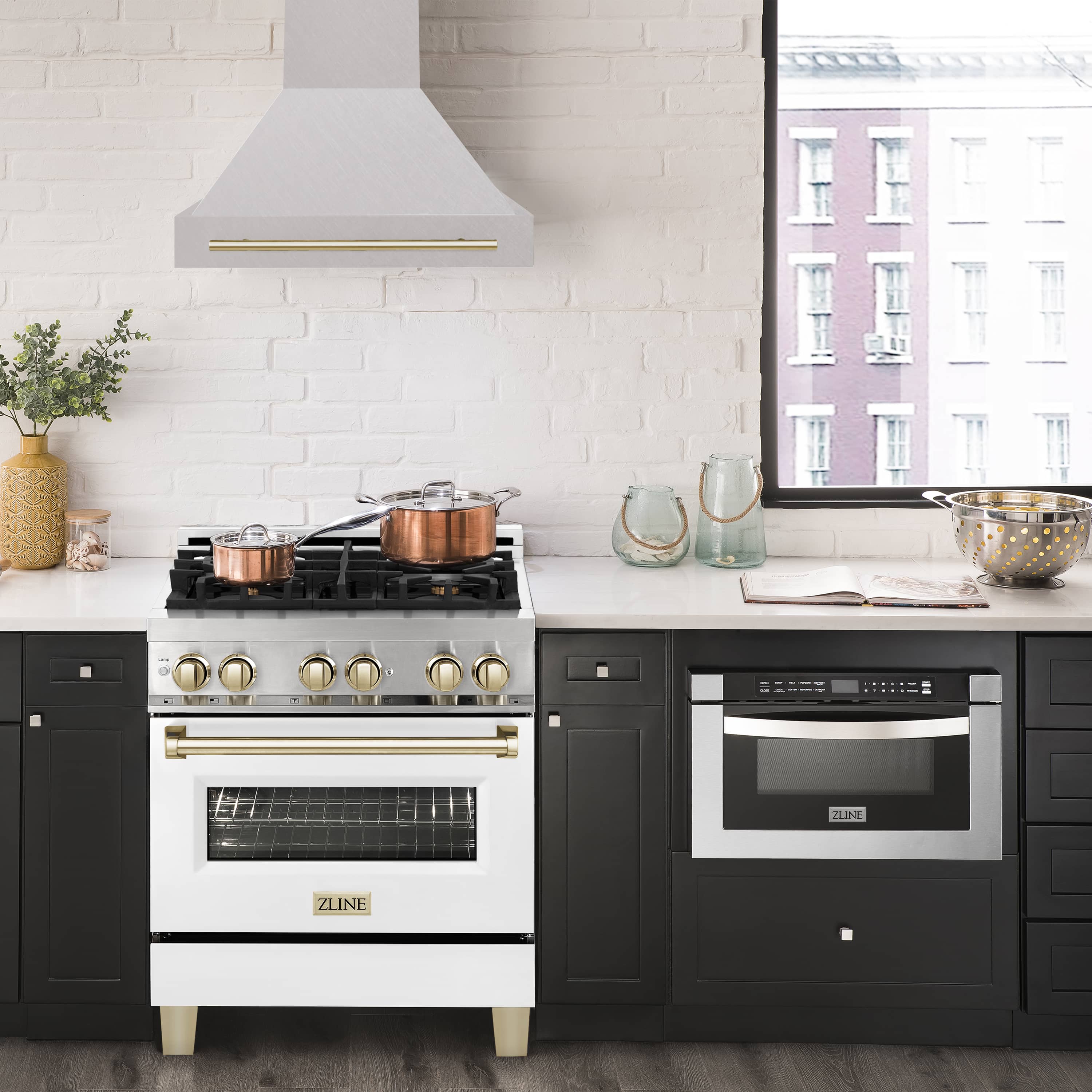 Wall-mounted range hood over cooktop with gold handle accents