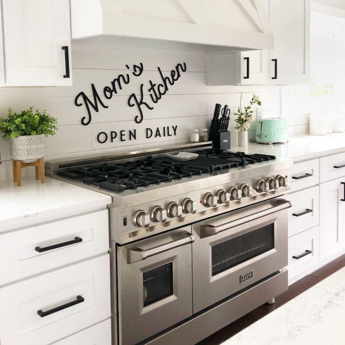 Stainless steel gas range with six burners, control knobs, and double oven doors